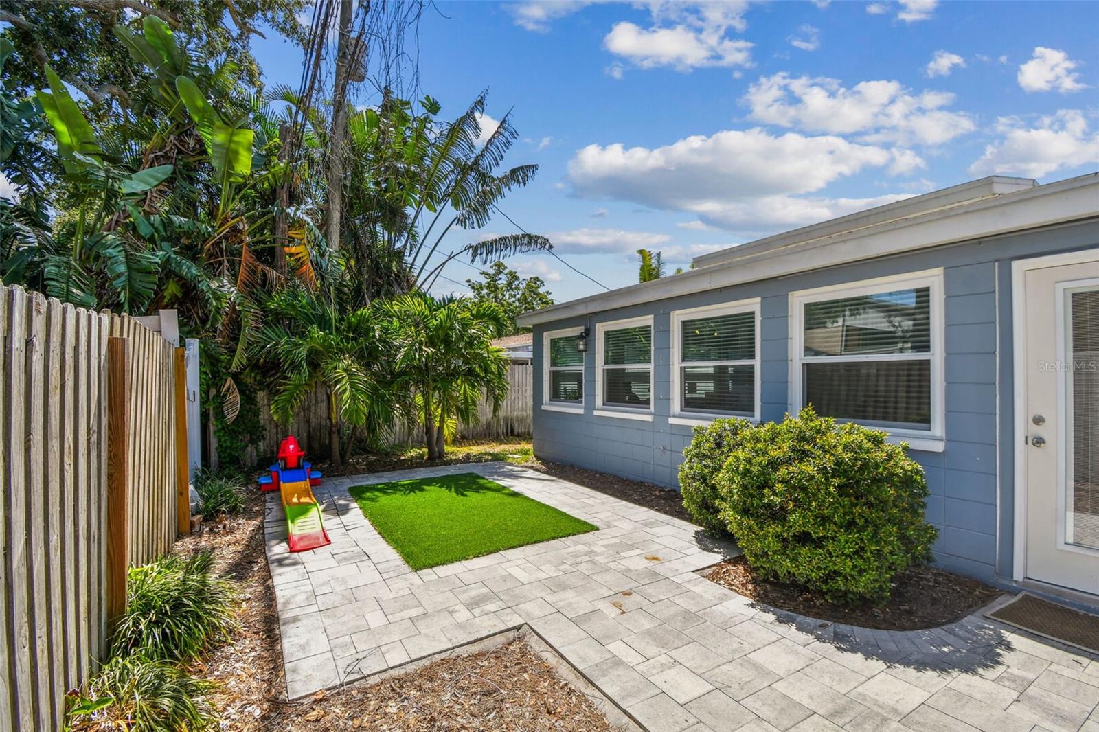 Renovated back yard features a bricked paved patio, new landscaping, artificial turf and an irrigated dog run area