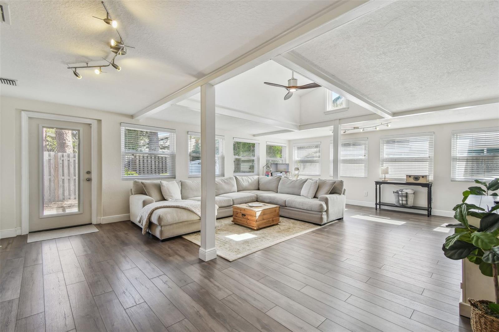 Great room - a grand space! Flanked by NEW windows & luxury laminate flooring - Vaulted ceiling