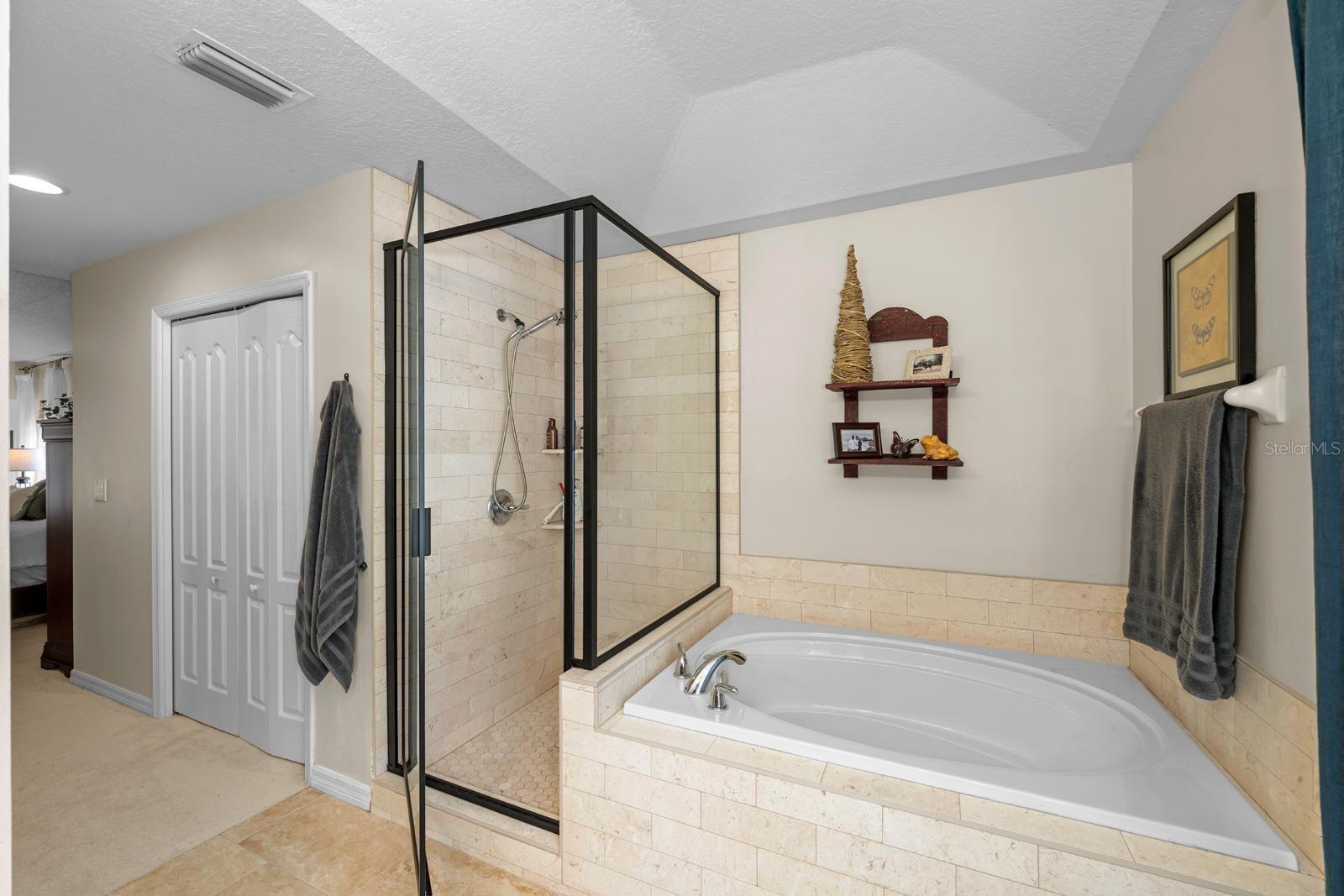 The Primary Ensuite is updated with new tile flooring, new lighting, granite counters, a framed mirror, and updated tile in the walk-in shower and around the garden tub!  It feels very luxurious walking in!