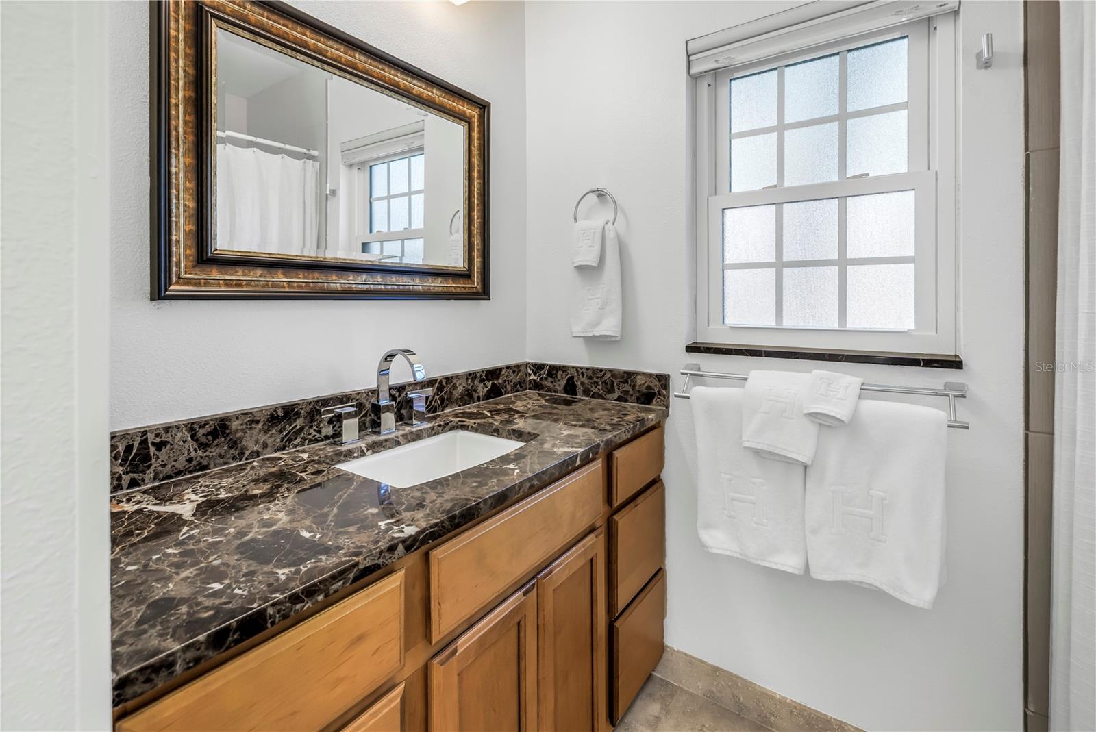Bath 2 features great matching vanity to the glass tile accents in the shower