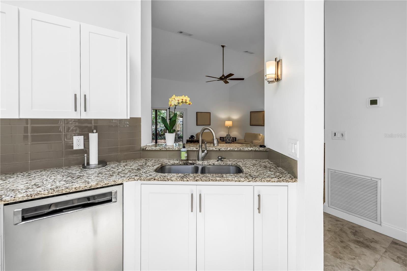 Open view to living space and backyard from Kitchen Sink