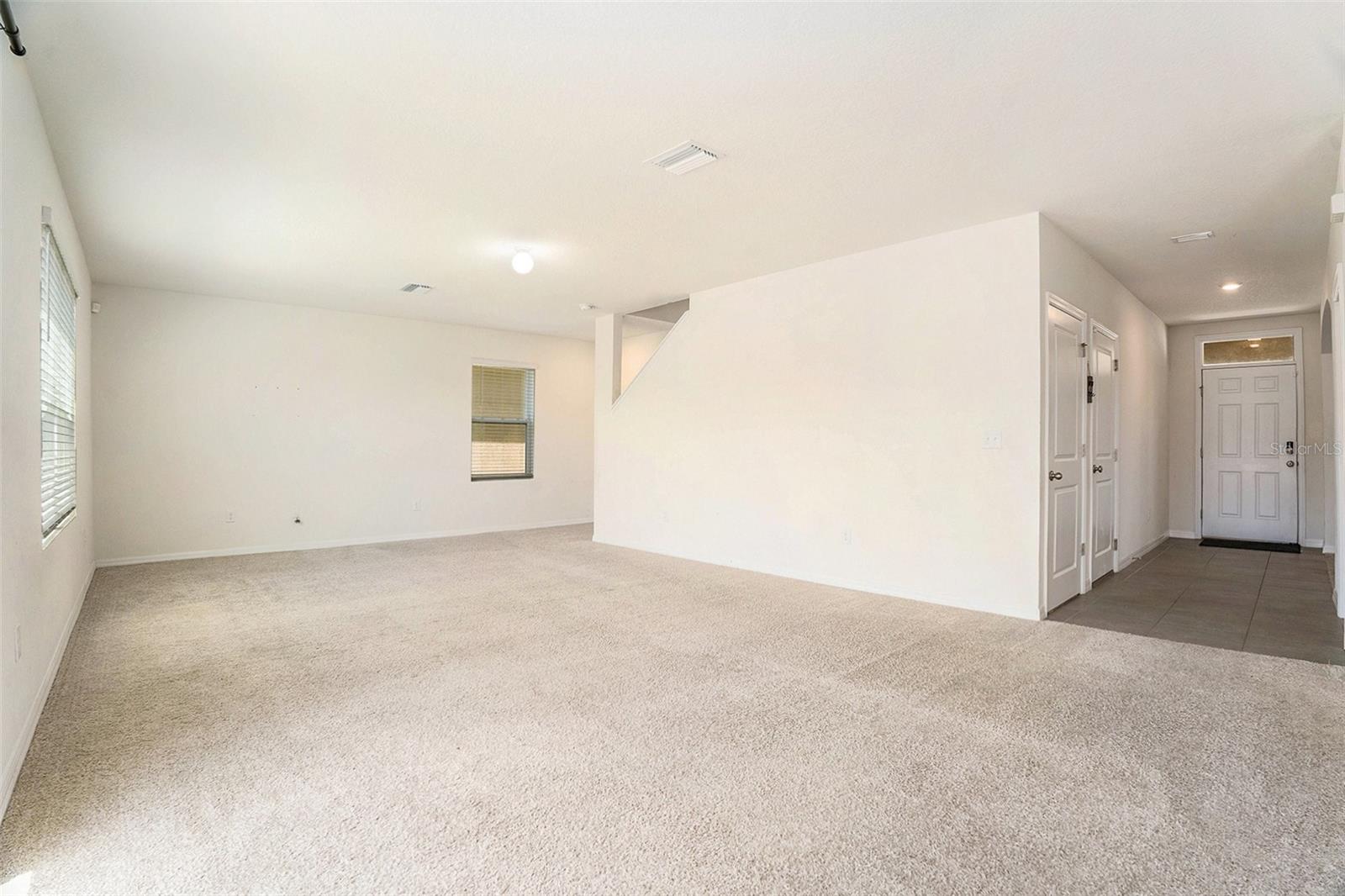 View of front door and living room, from kitchen.