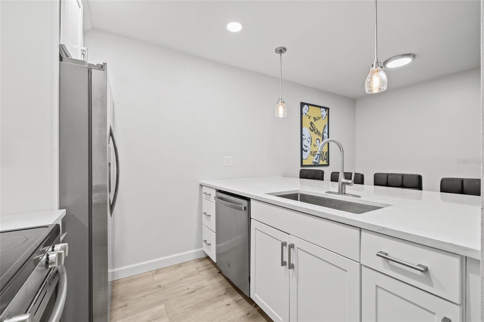 The kitchen has been opened up by removing a wall, creating a more spacious and open-concept feel that flows seamlessly into the living area.