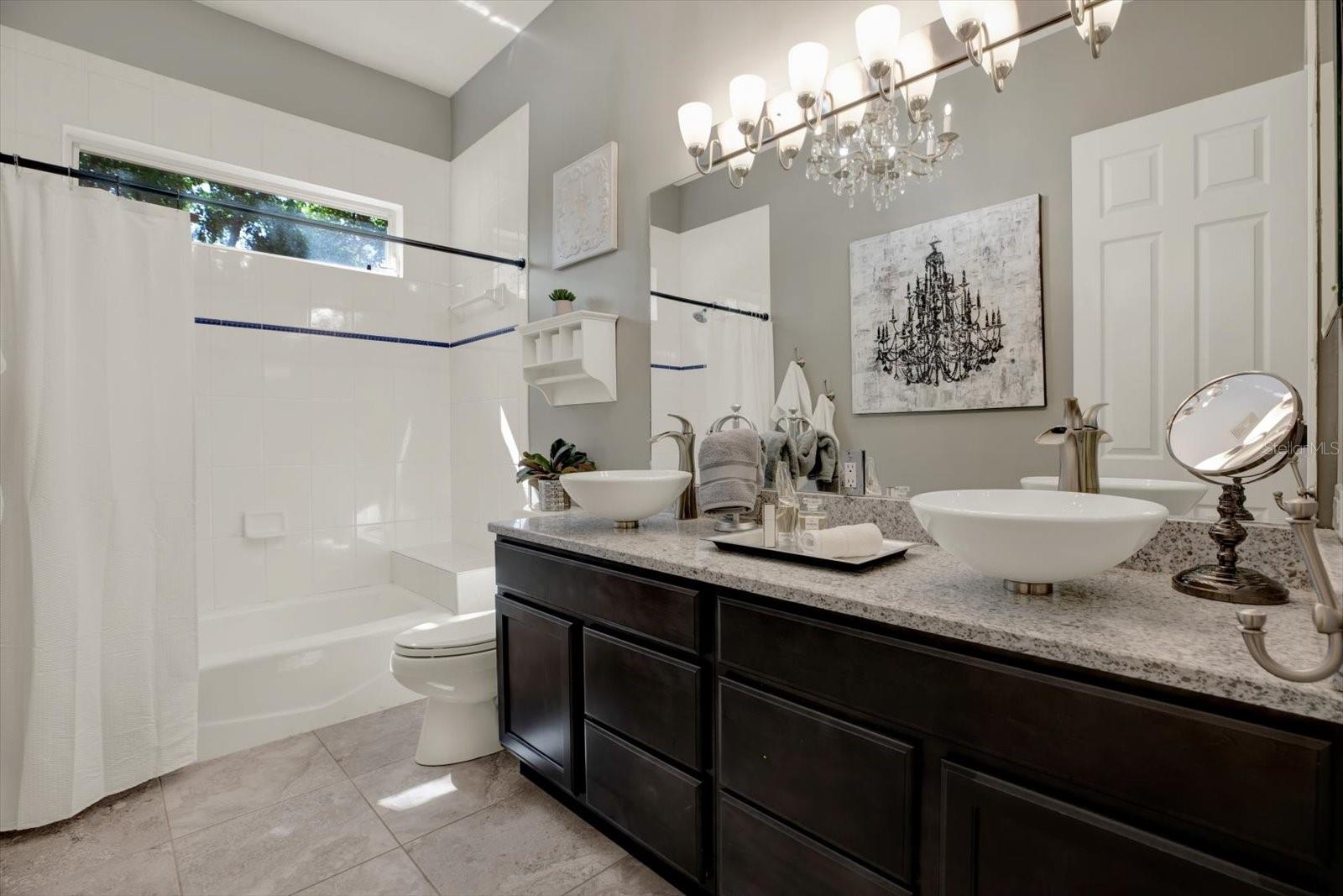 Full upper level bathroom with tub/shower and dual sinks.