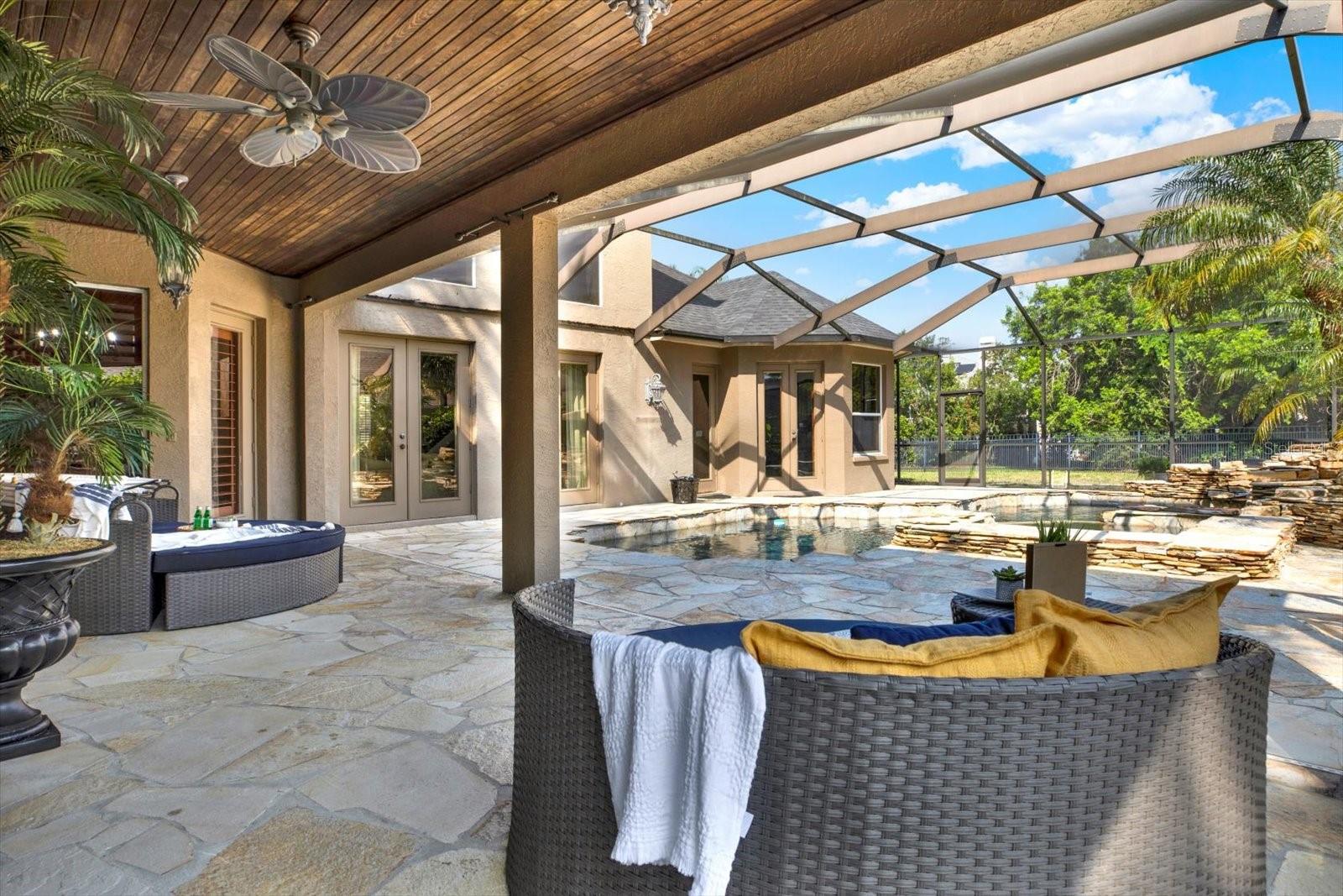 Oversized covered lanai with beautiful wood trimmed ceilings perfect for relaxing and listening to the waterfall spillover spa.