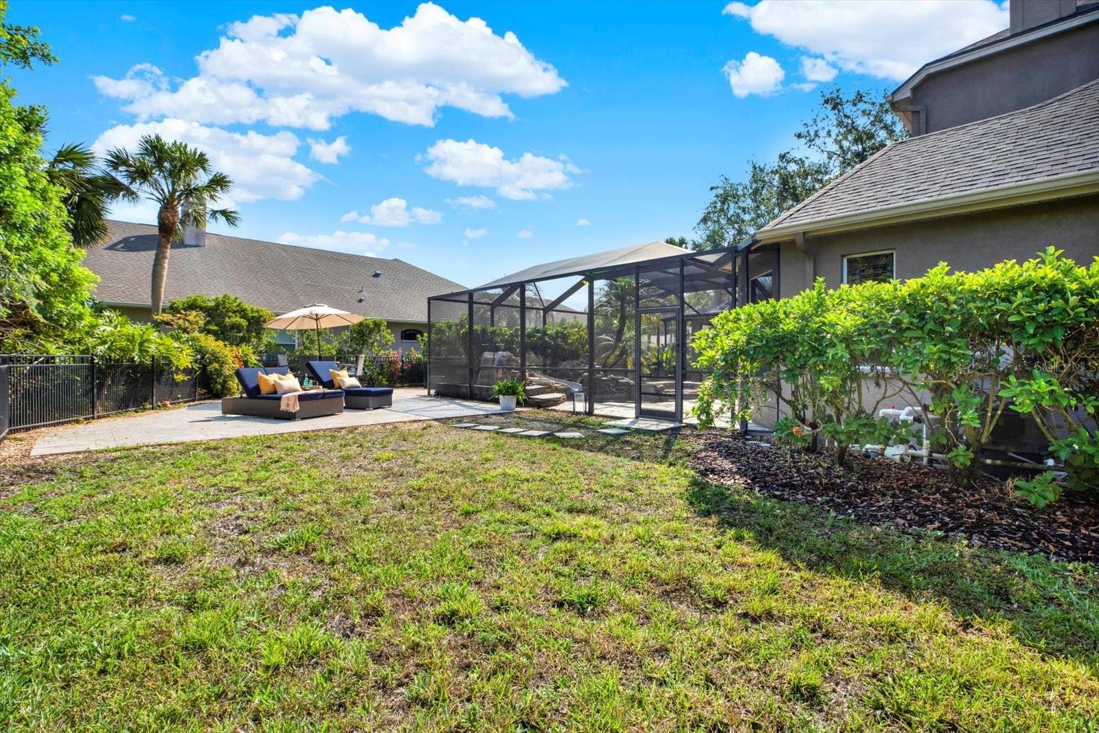 Fully fenced yard with paved sundeck.