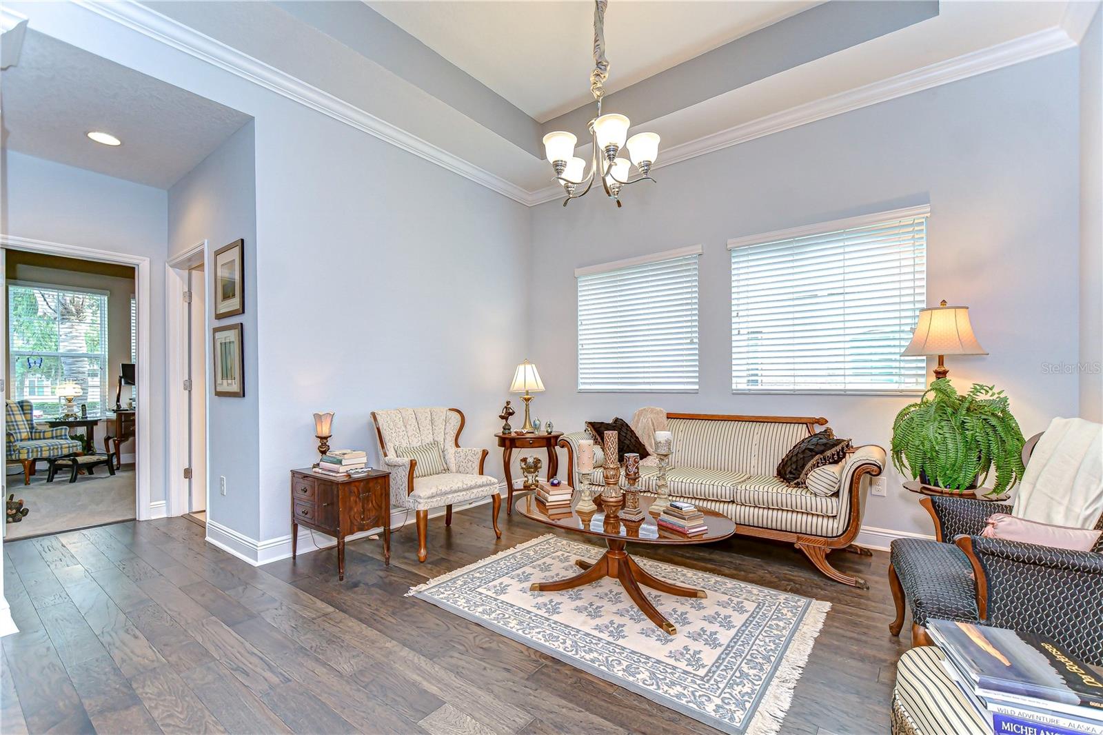 A formal living room boasts tray ceiling and crown molding!