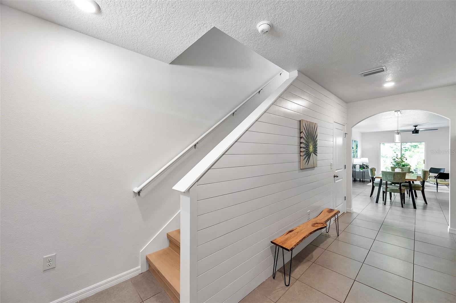 As you enter you see the stairs and view through the kitchen, dining room, living room and out to the back patio