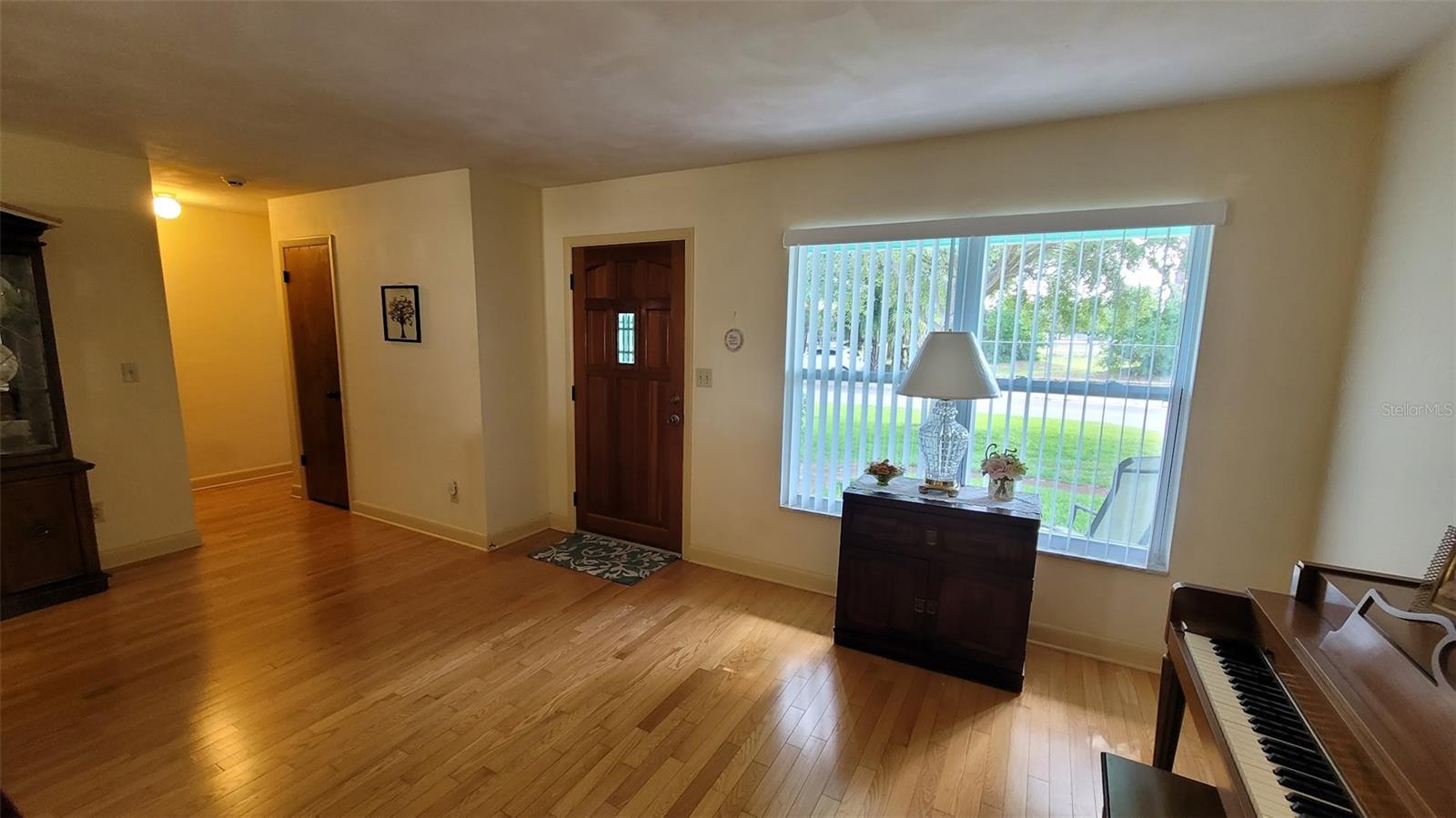 The entry door brings welcomes you into the front living room of the home. The piano can stay and be enjoyed by the new family if interested in it.