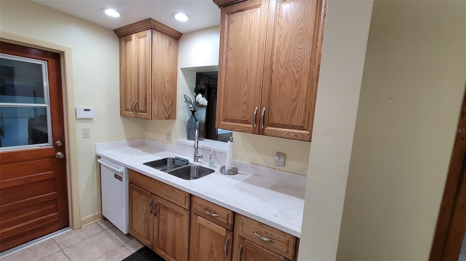 The kitchen was updated 7 years ago. New appliances, cabinets, counters, and lighting. There is a passthrough to the near by Family Room. The door you see leads to the garage making it convenient after shopping trips.