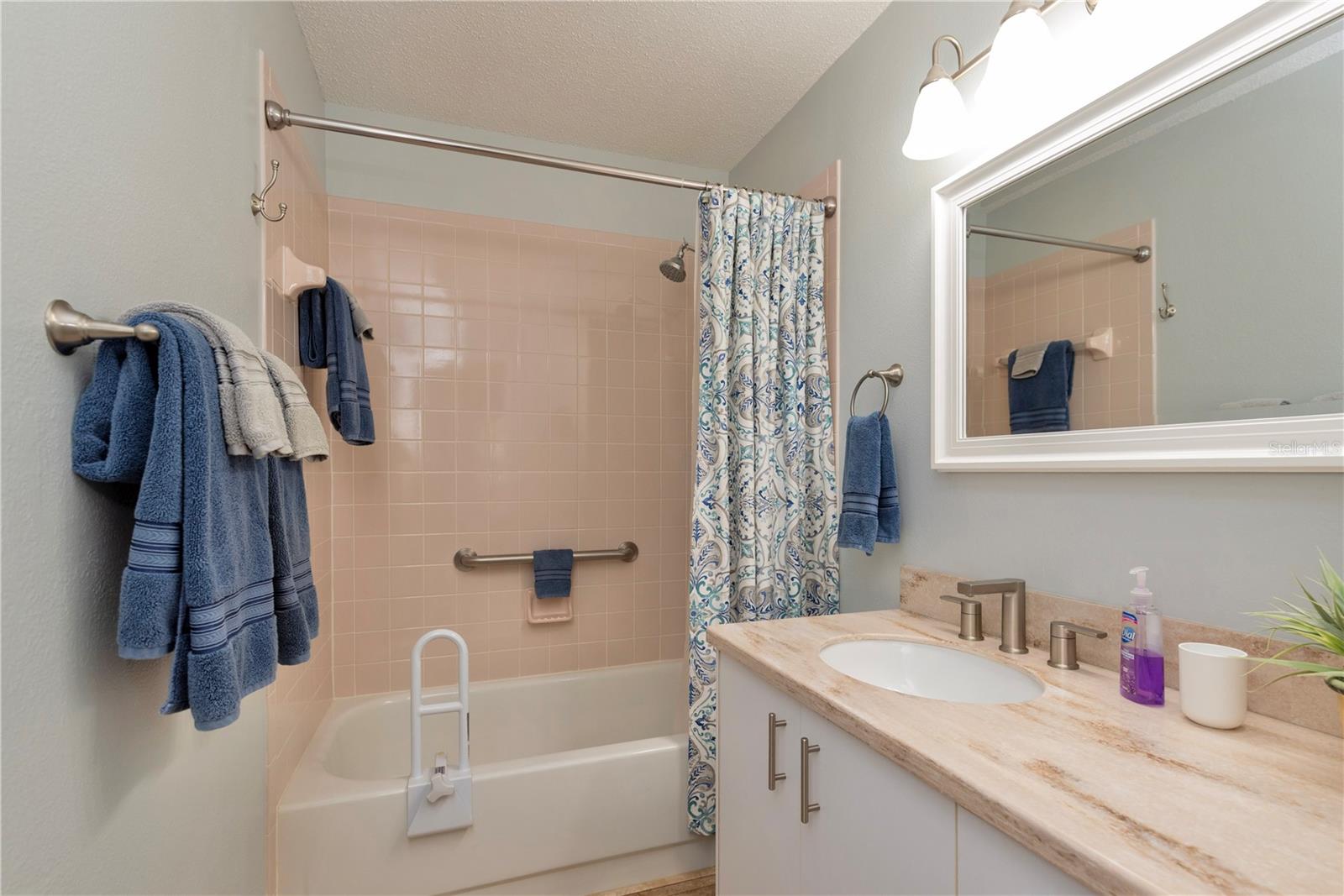 Guest bathroom with tub/shower and granite counters.
