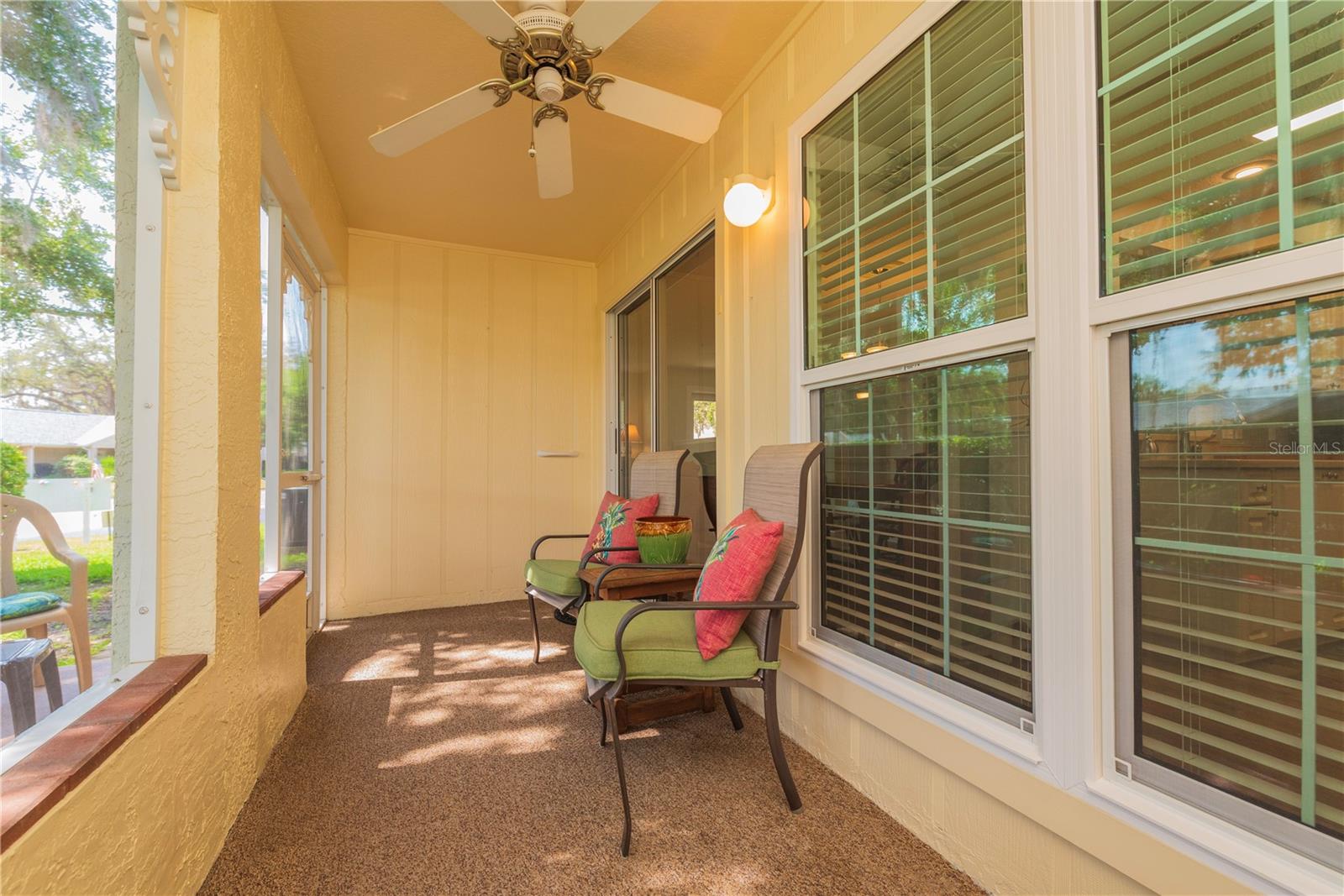 Screen porch has a ceiling fan.