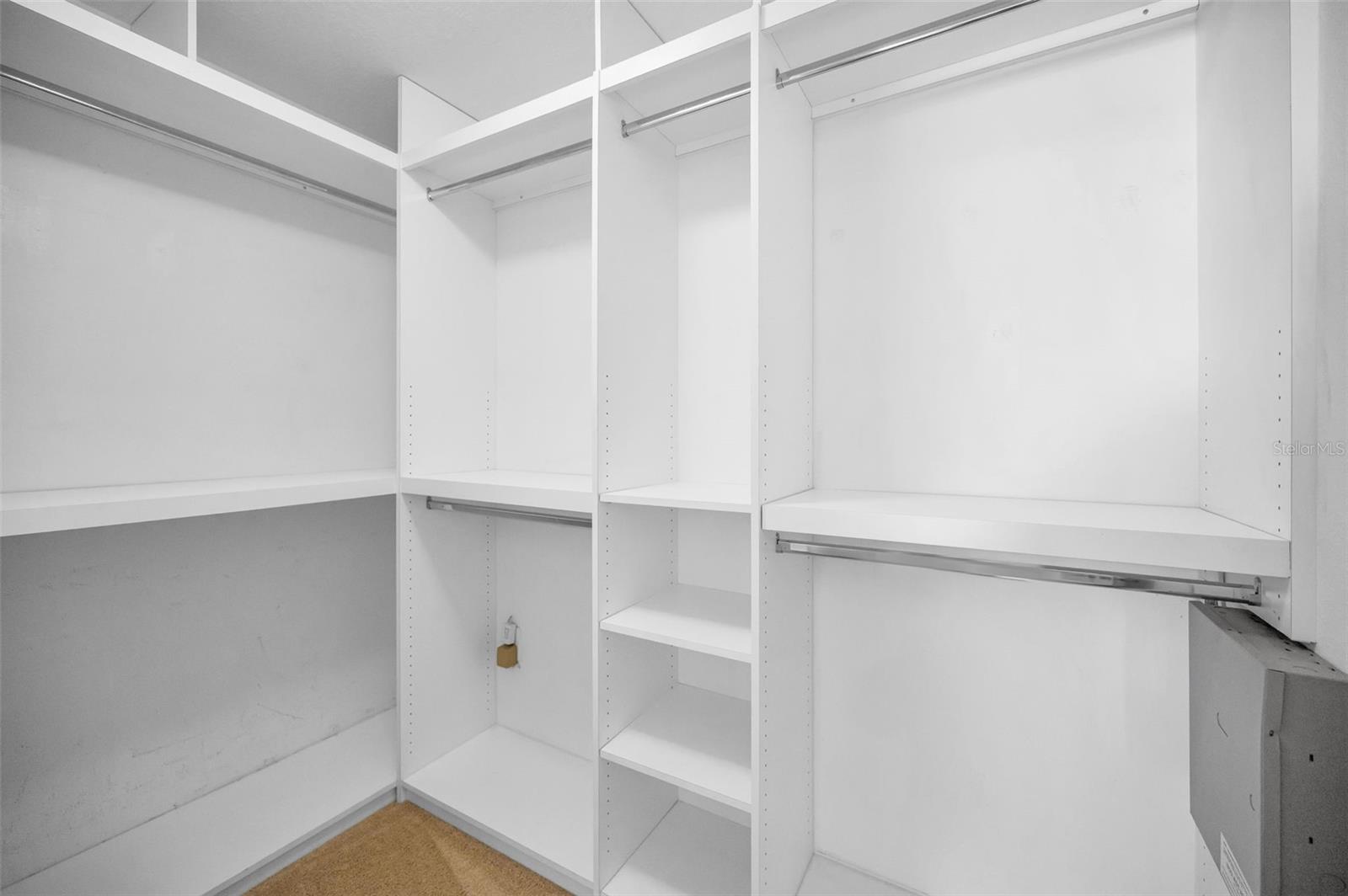 Walk-in closet in primary bedroom with custom closet organizer