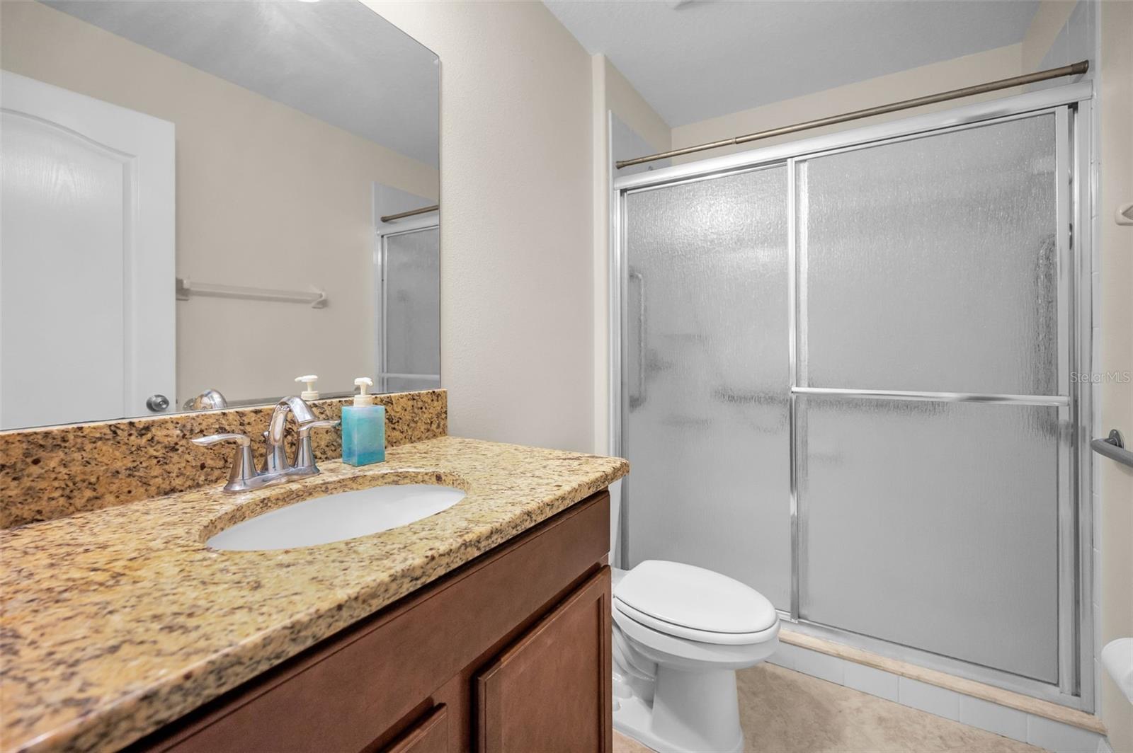 2nd bathroom with granite countertops and a walk-in shower