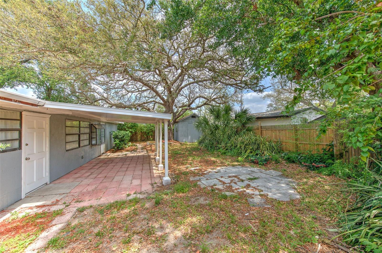 fully fenced backyard with patio and fire pit area