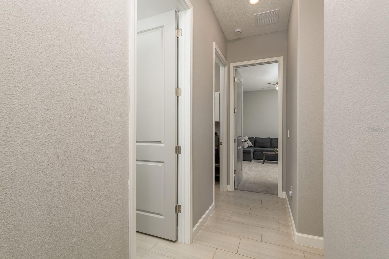 Hallway to half bath, laundry room, 2nd bedroom and garage entrance