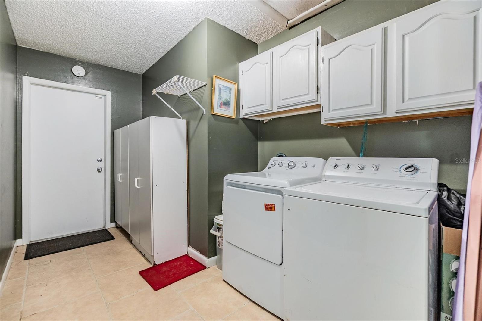 Large laundry room; storage cabinets can stay