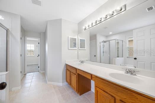 Primary Bath with Dual Sinks, private commode area, new lighting and medicine cabinets, leading to the huge walk-in closet