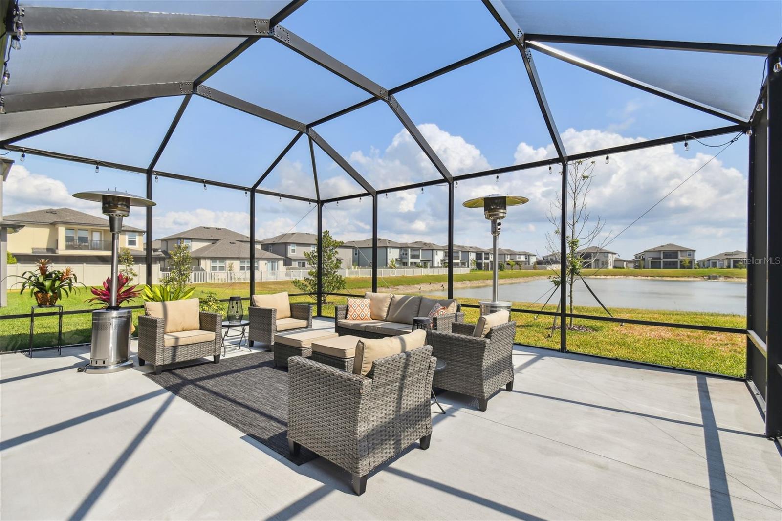 Owners invested in adding the additional pad and screen enclosure to create an outdoor space overlooking the water. The pond is shown here at the height of the dry season. Enjoy watching the numerous birds and wildlife that visit daily.