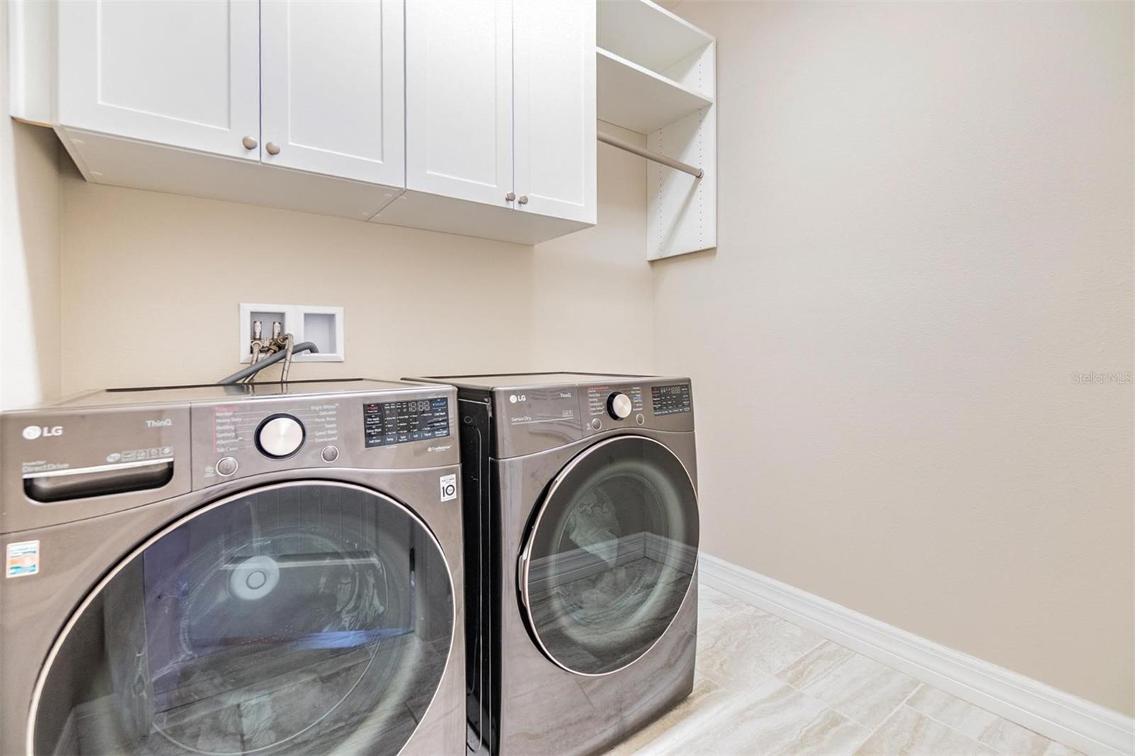 upstairs laundry room with cabinetry and hanging bar