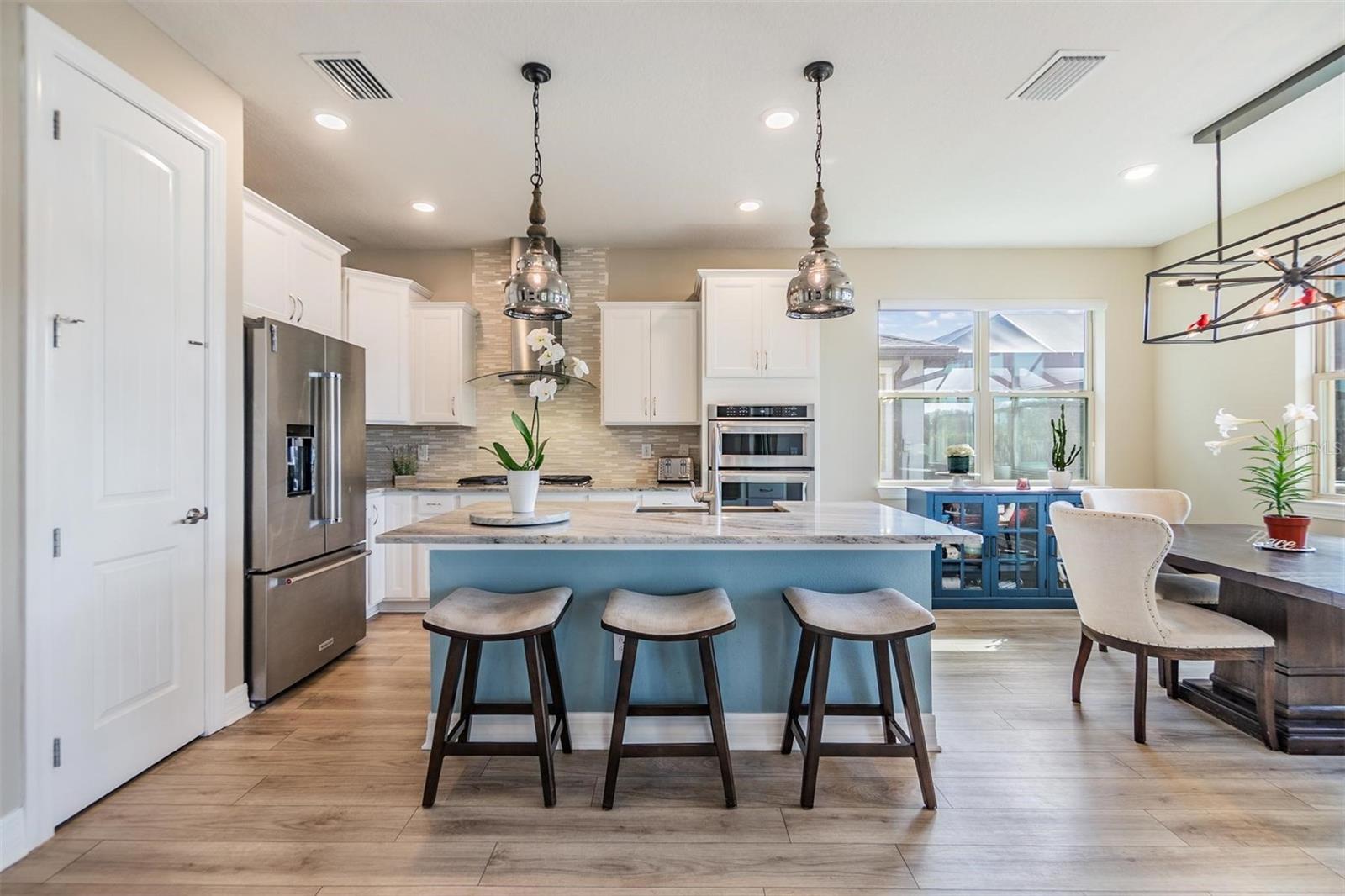 gourmet kitchen with built-in oven and microwave, gas cooktop, stainless range hood, and apron front stainless sink!