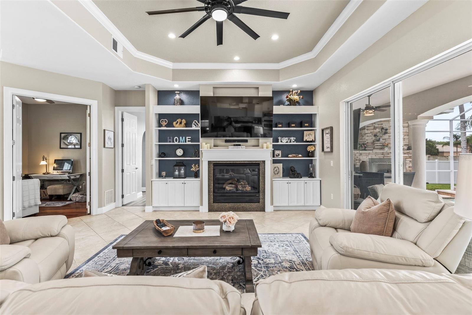 Spacious living room with tray ceilings and built in gas fireplace