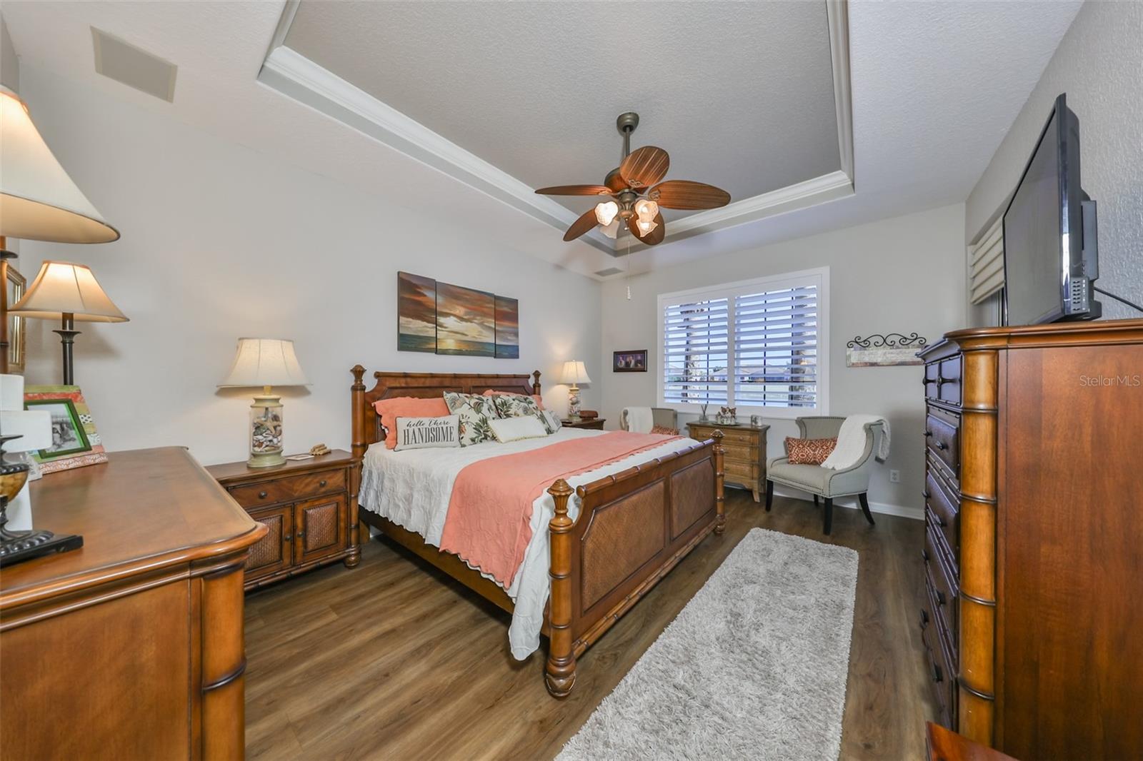 The master bedroom is luxurious and comfortable.  With high ceilings, custom fan and luxury vinyl planks make this a perfect get away from the hustle and bustle.