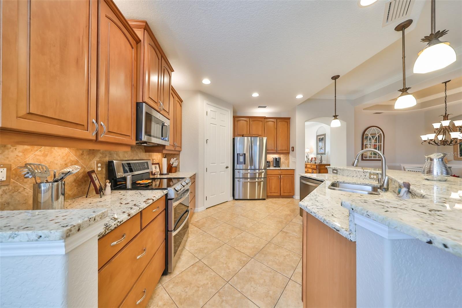 The kitchen boasts of modern granite, custom 42" wood cabinetry and stainless steel appliances with a huge walk in pantry.