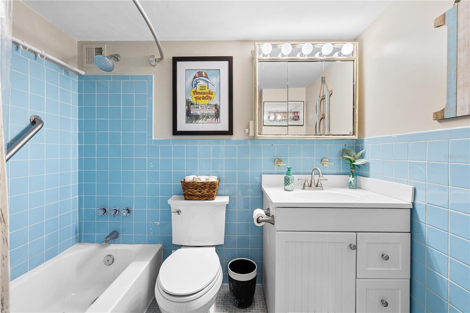 Hall way bathroom is an ample size. Has vintage features, yet in tasteful, beachy colors.