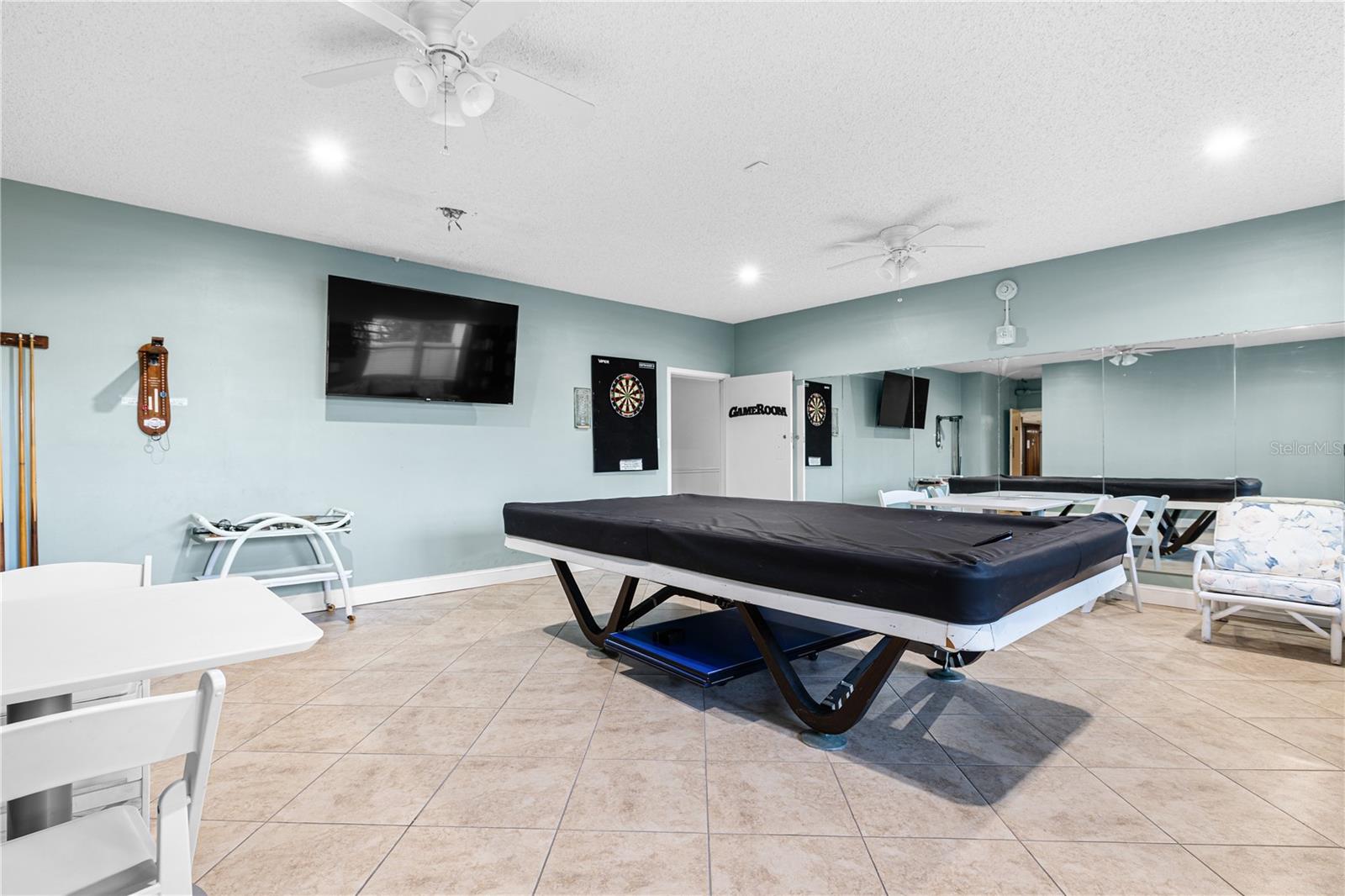 The game and billiards room offers a full size pool table, darts and more. Not pictured is the community library.