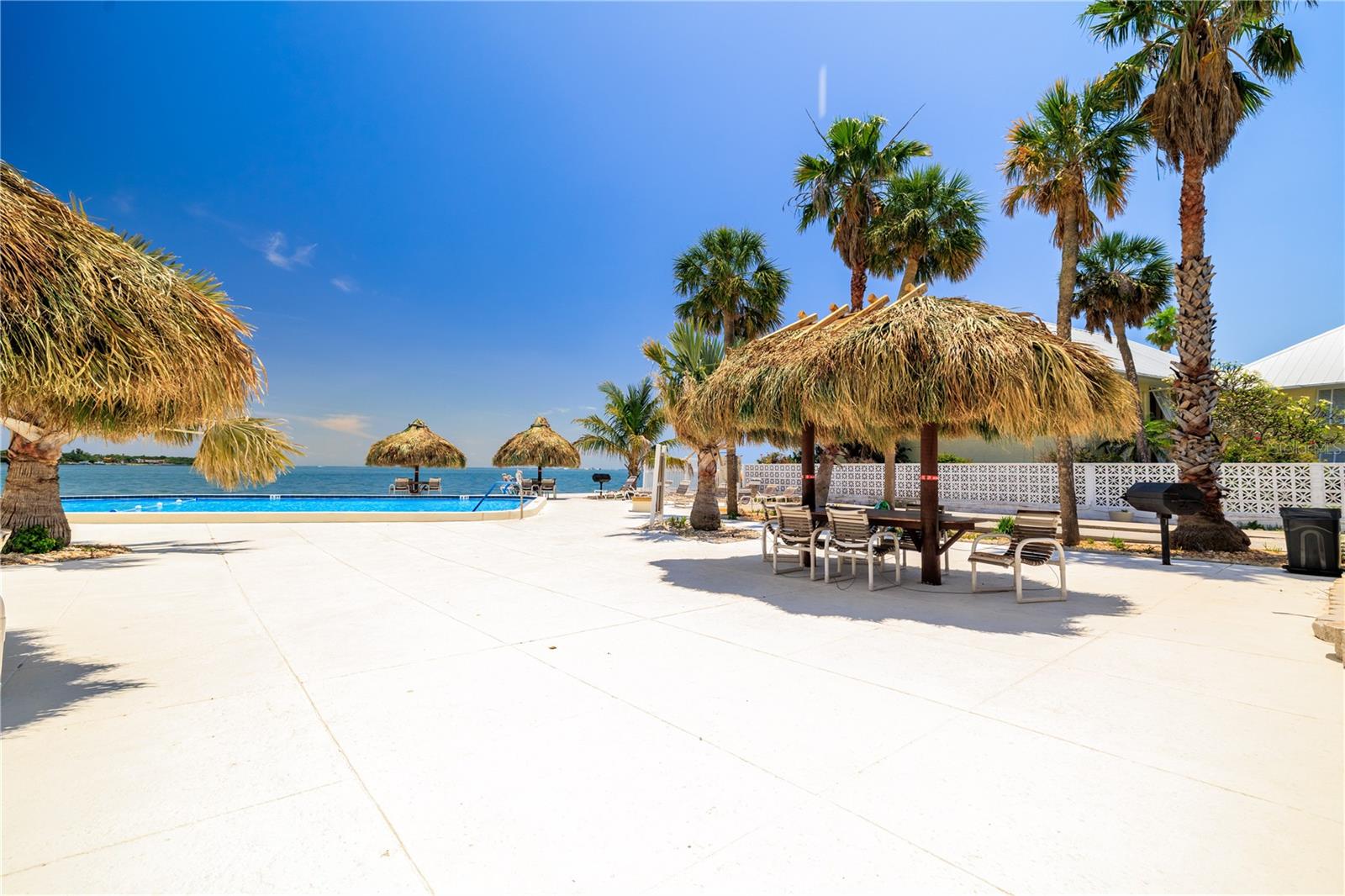 Huge pool deck has tiki huts, sun lounger area, shuffle board, grills, and outside his and hers bathrooms!