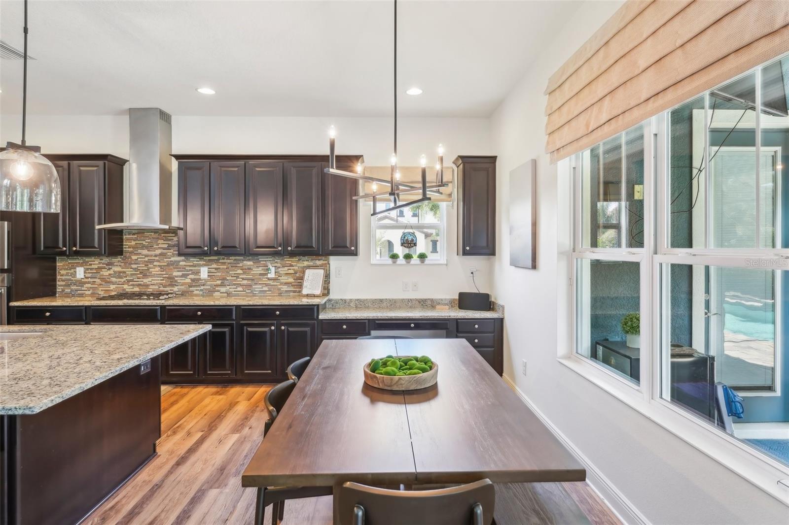 BREAKFAST NOOK HAS SPECTACULAR VIEWS OF THE POOL AND OUTSIDE! CUSTOM BUILT IN DESK AREA ADDS ADDITIONAL WORK SPACE!