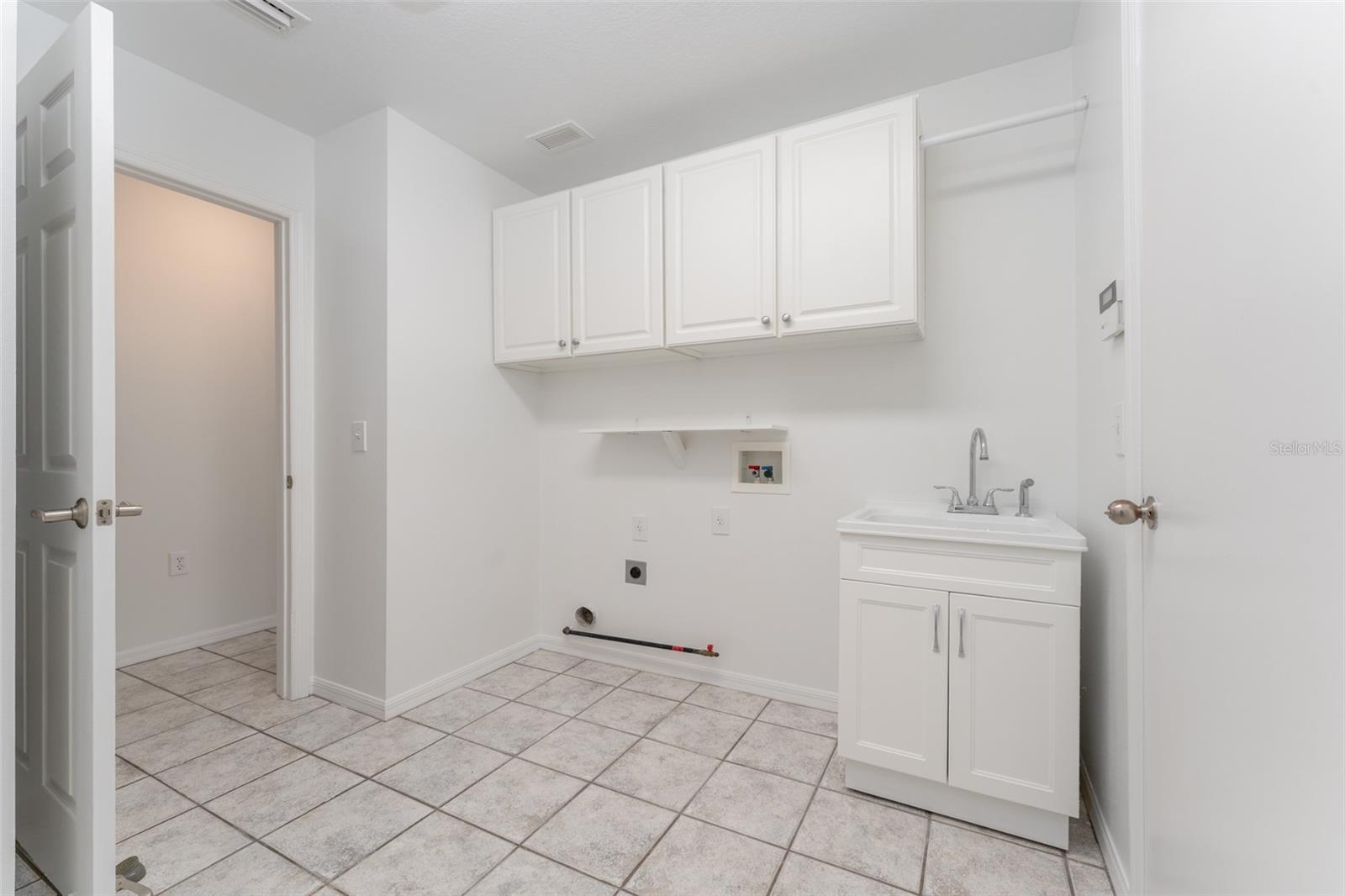 gas hook up for dryer, cabinets, drying bar & utility sink. Laundry room also has a dedicated space for a refrigerator!