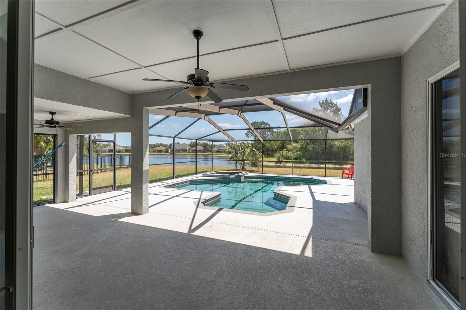 view of the lanai, pool/spa & pond from the living room glass sliding doors