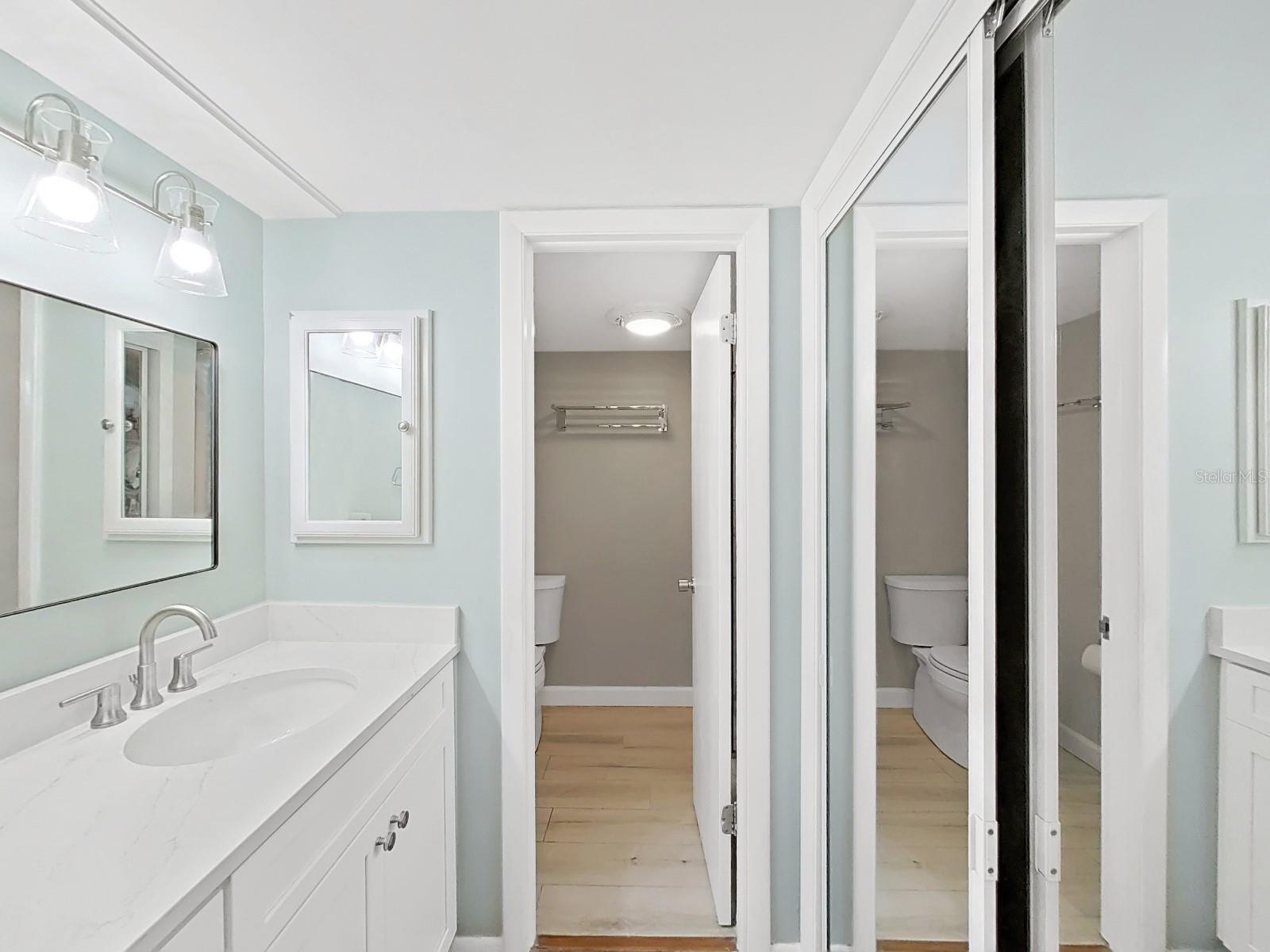 Primary Bathroom with new cabinetry, Quartz countertop, mirror and lighting!