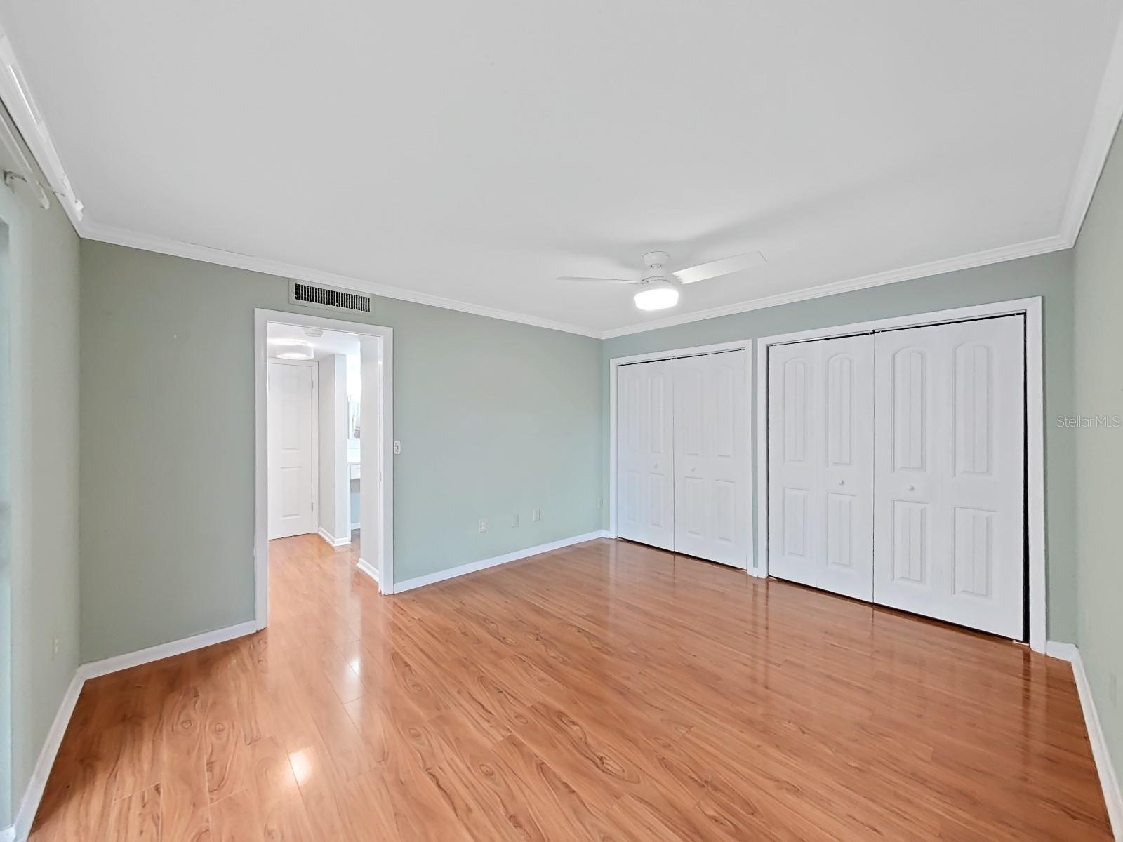Spacious Primary Bedroom with new Hunter ceiling fan, multiple closets & access to the screened Lanai through NEW 8' sliding glass door.