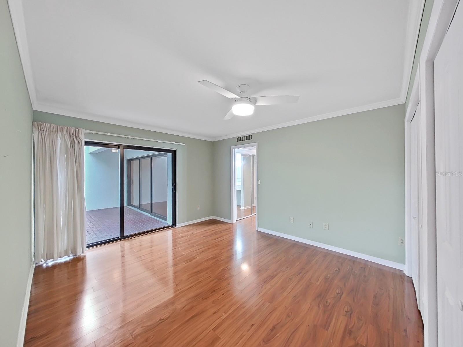 Spacious Primary Bedroom with new Hunter ceiling fan, multiple closets & access to the screened Lanai through NEW 8' sliding glass door.