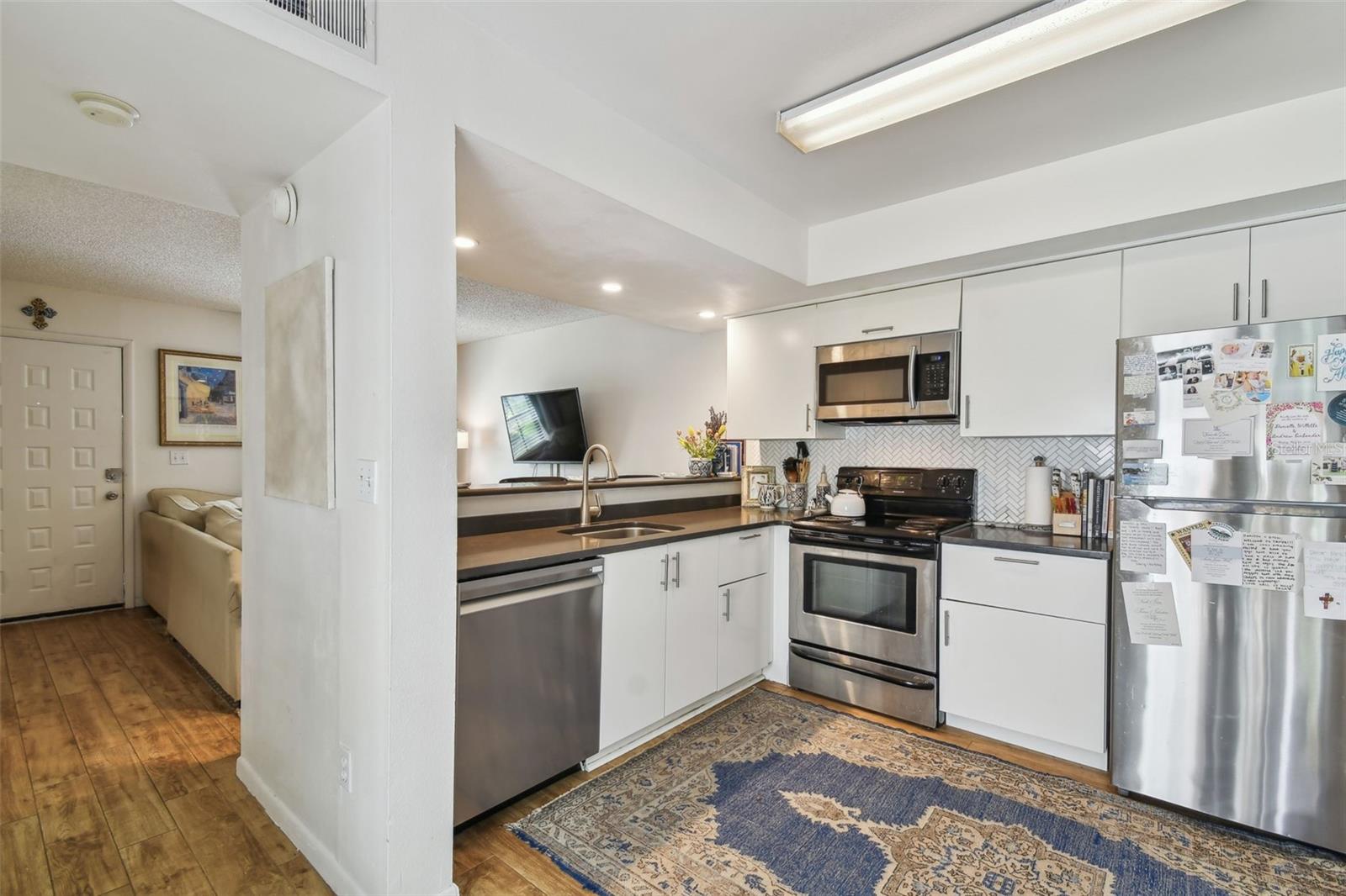 Modern cabinetry, stainless steel appliances, and pass-through countertop for easy serving.