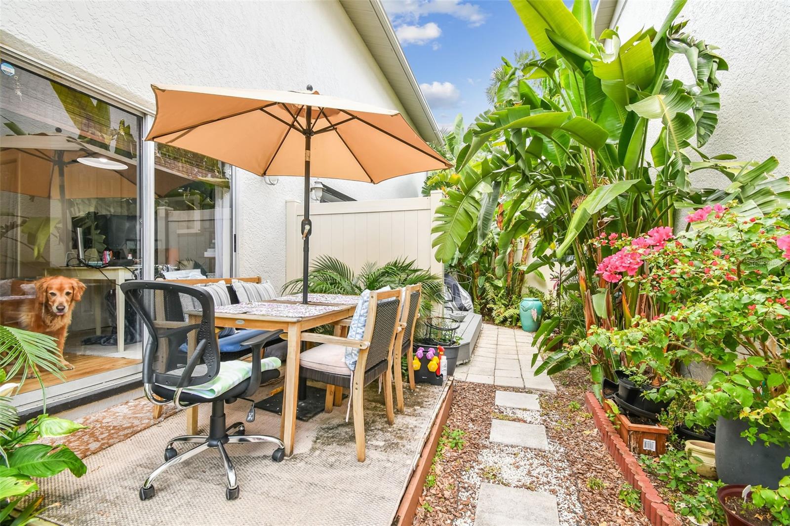 Secluded outdoor dining space with mature tropical landscaping