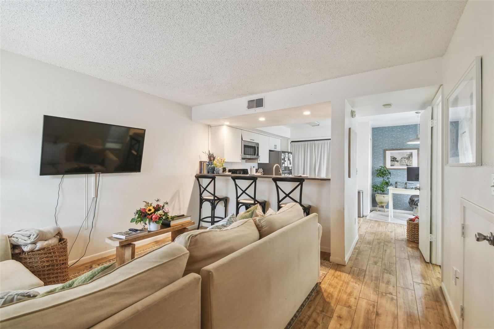 Bright living room opening to a breakfast bar, perfect for casual dining and entertaining.