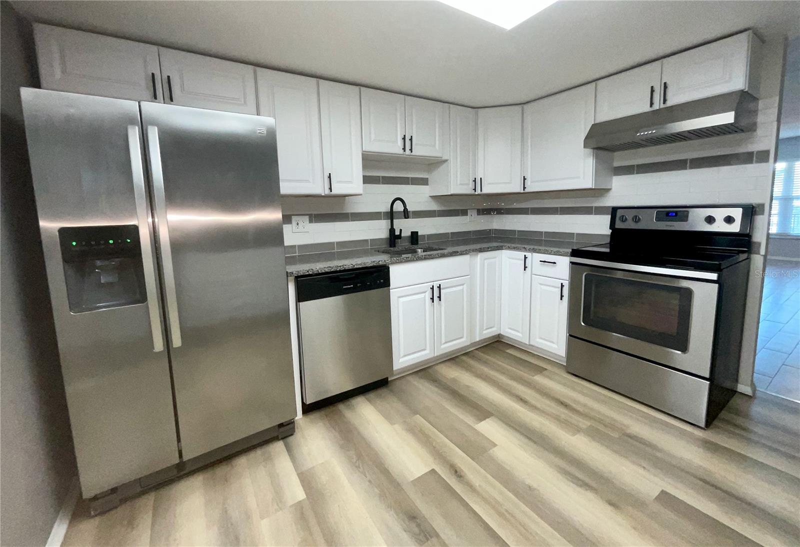 9-Kitchen sink area with frig, dishwasher and range