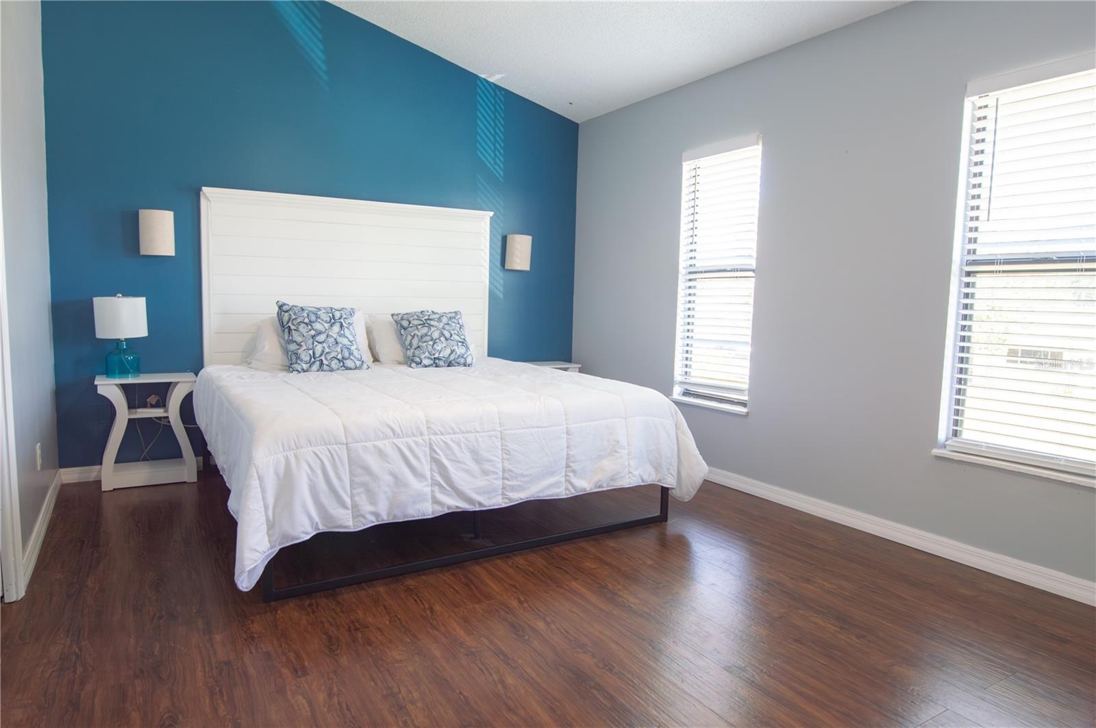 PRIMARY BEDROOM WITH VAULTED CEILINGS AND EN SUITE BATHROOM.