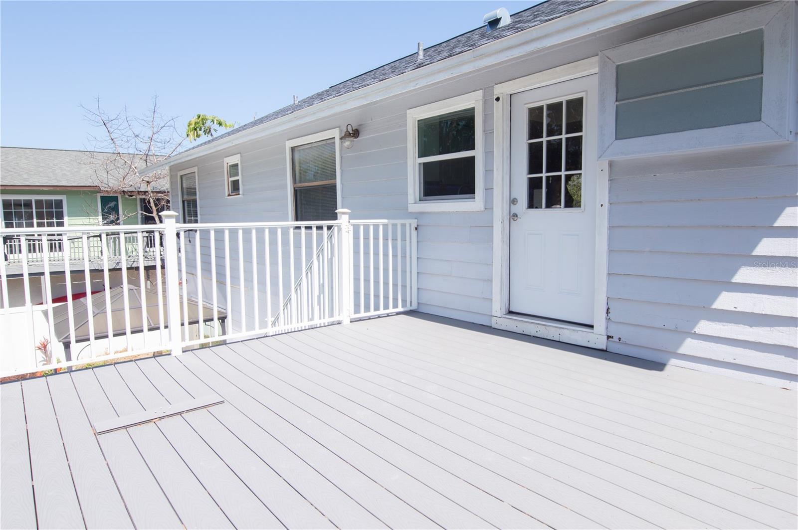 DECK OFF OF THE KITCHEN WITH STAIRS LEADING DOWN TO THE POOL.