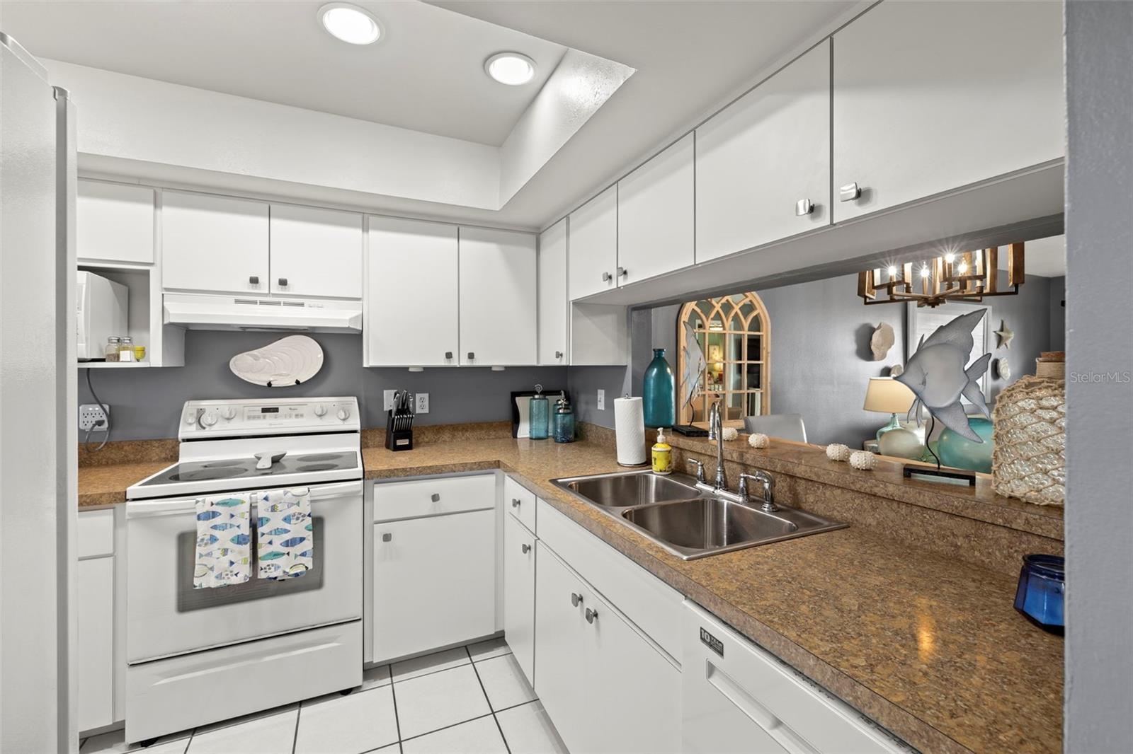 Bright white kitchen with recessed lighting, and matching white appliances.