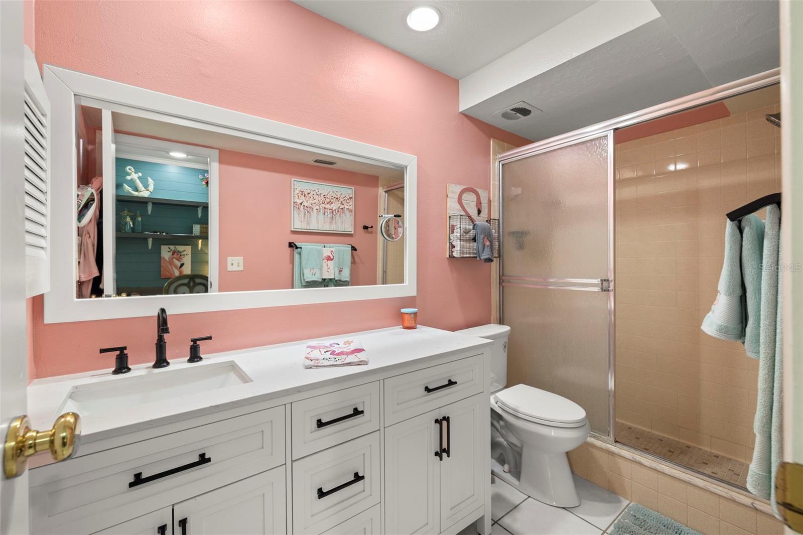 Primary en-suite bathroom with walk-in shower, newer bathroom vanity with soft close drawers, new vanity mirror, comfort height toilet and recessed lighting.