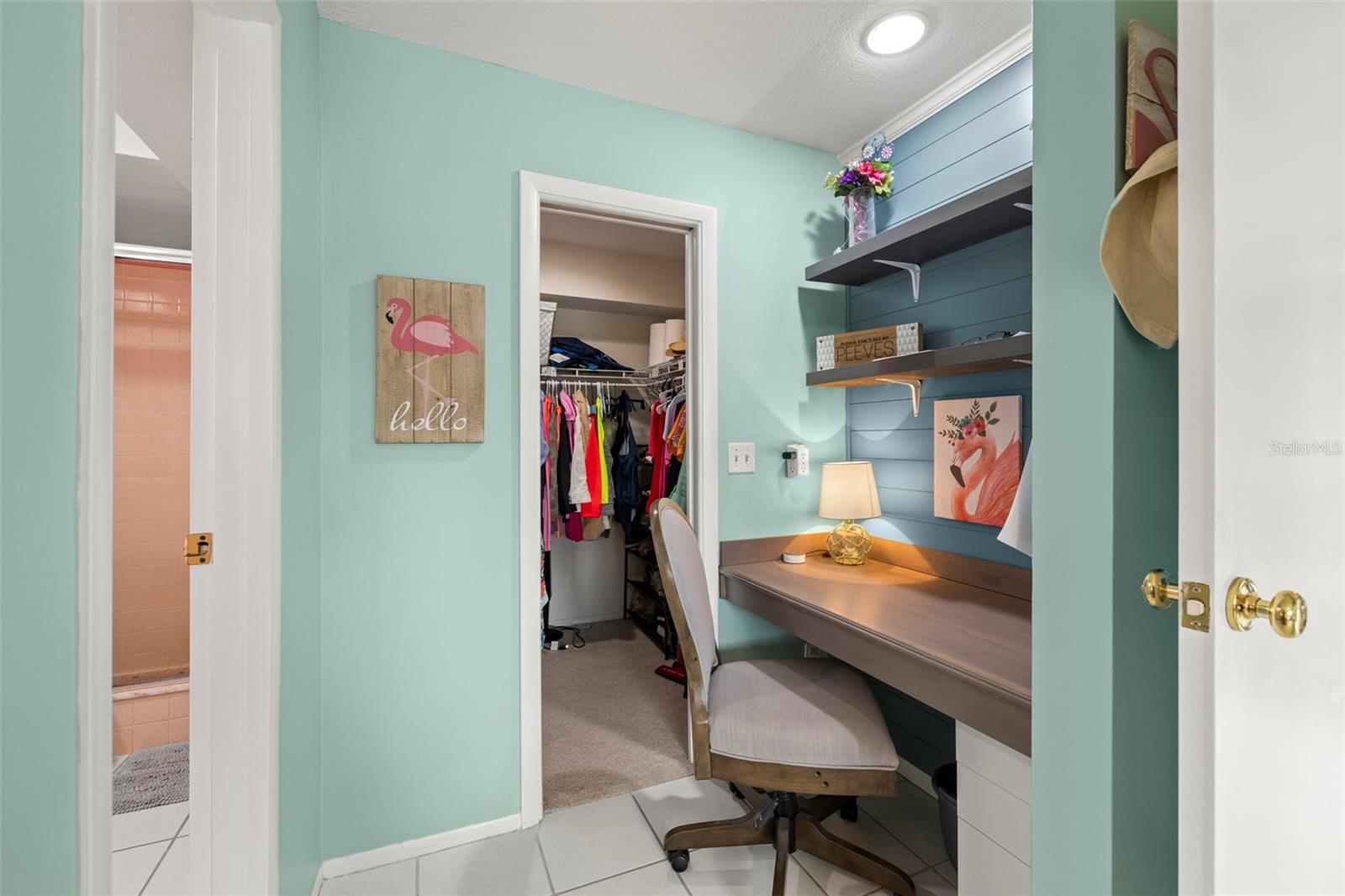 Built in desk/office area in the primary bedroom decorated with on-trend shiplap and cool coastal colors.  Walk-in closet with plenty of storage!
