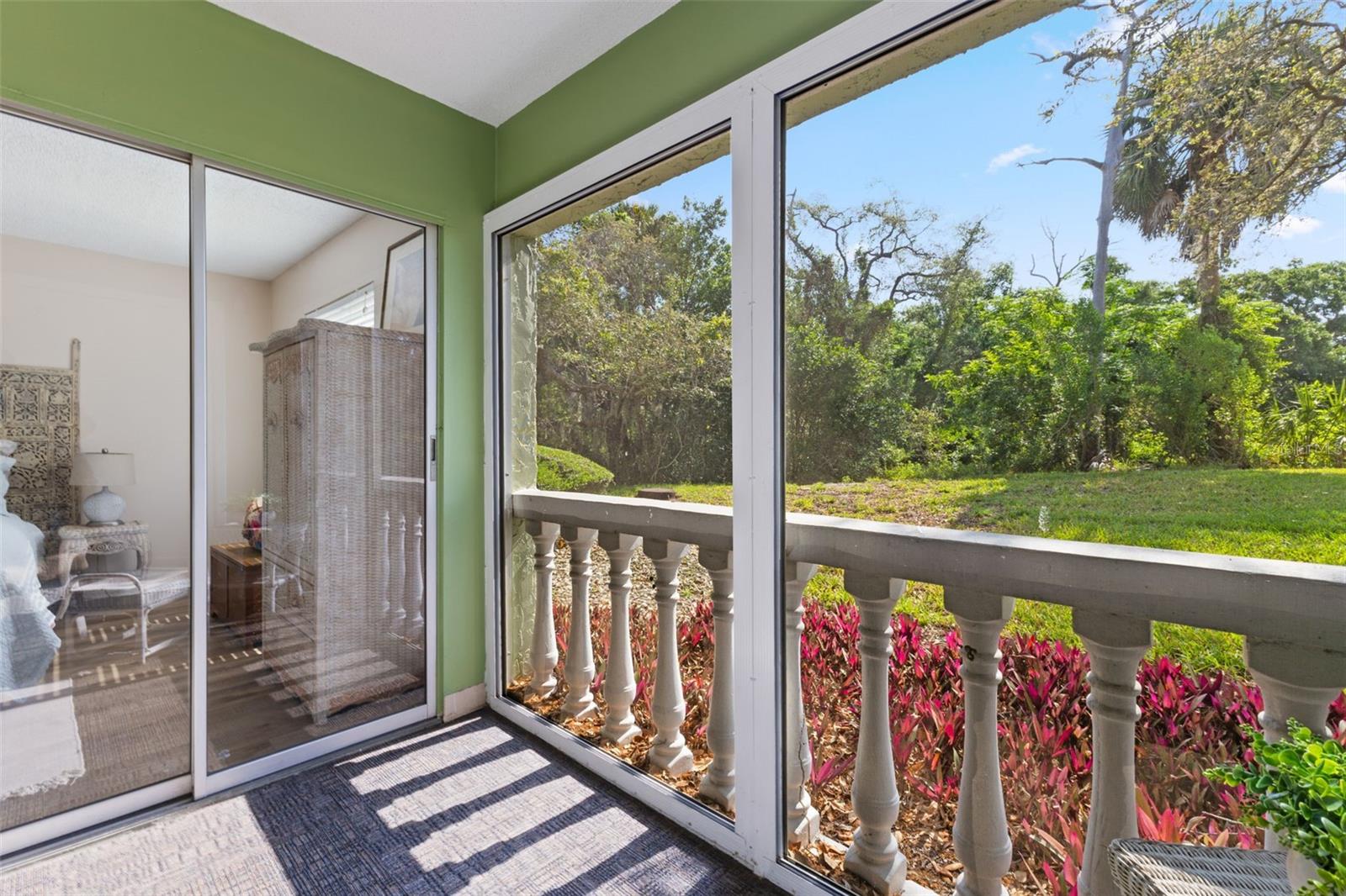 Screened in Rear Lanai, sliding door leading into the Primary Bedroom