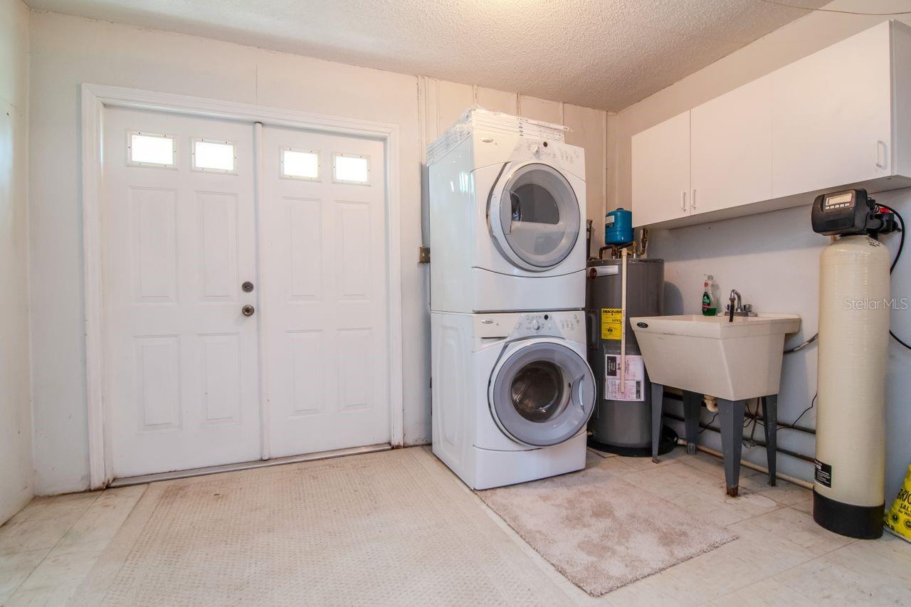 This garage boasts plenty of room for storage, indoor laundry facilities, easy access to the water purifier, and French doors leading to backyard.