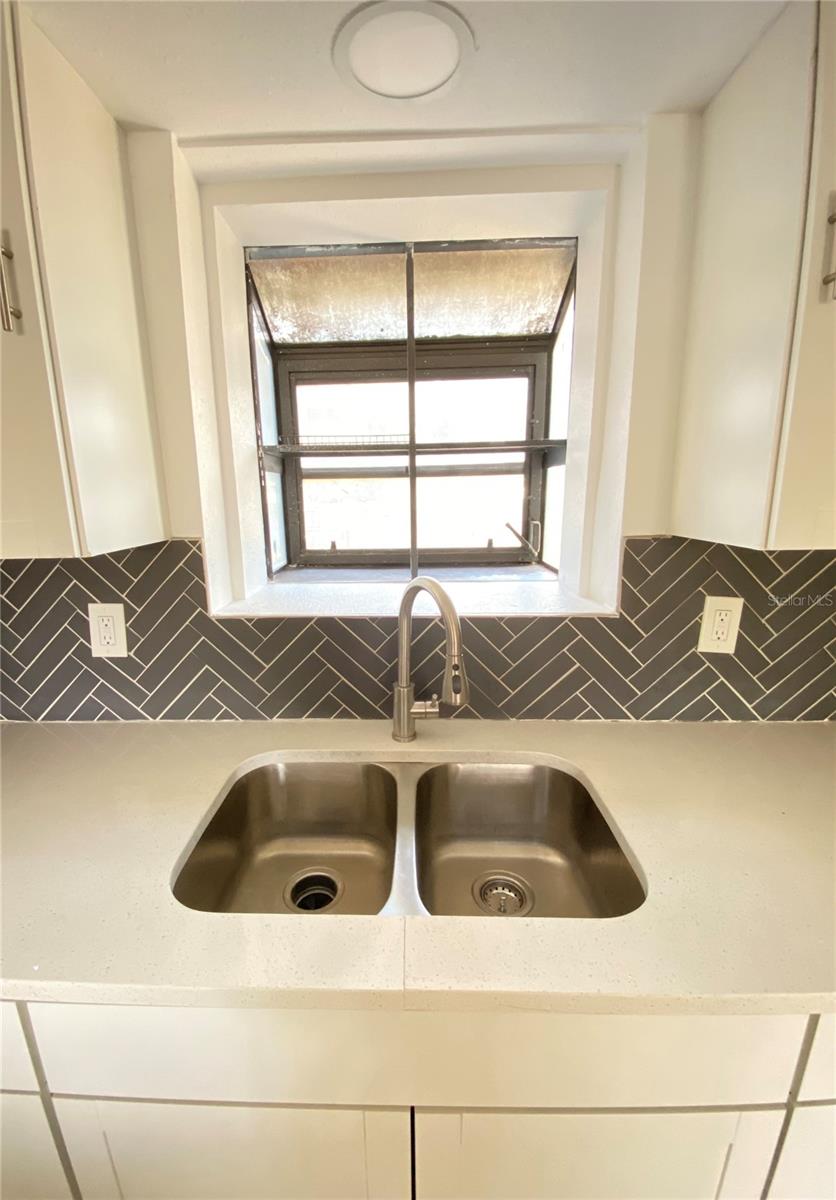 Beautiful double sink and custom window allowing great light in and view of back yard