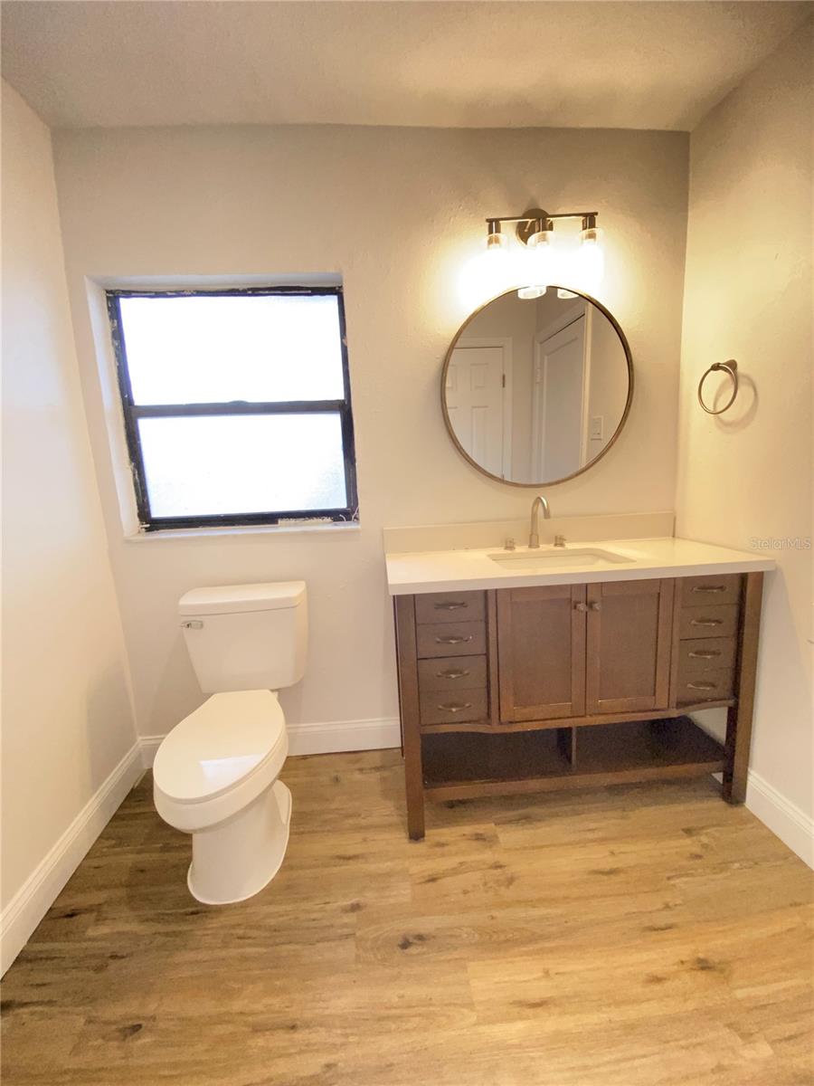 Primary bathroom vanity with large mirror and modern hardware